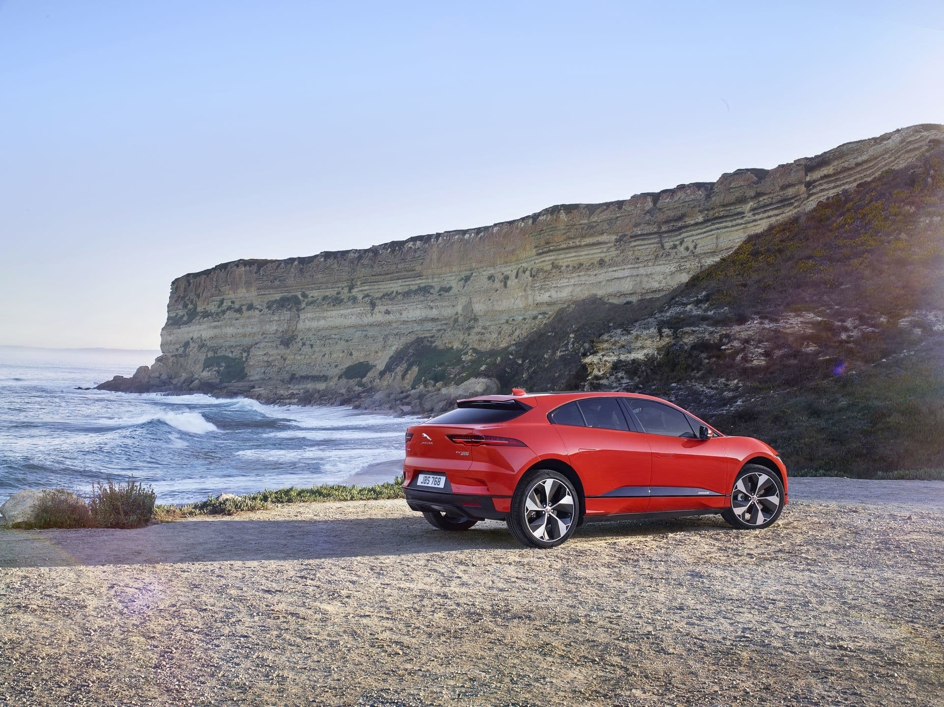 Imagen trasera del Jaguar I-Pace en un entorno costero, fusión de naturaleza y tecnología.