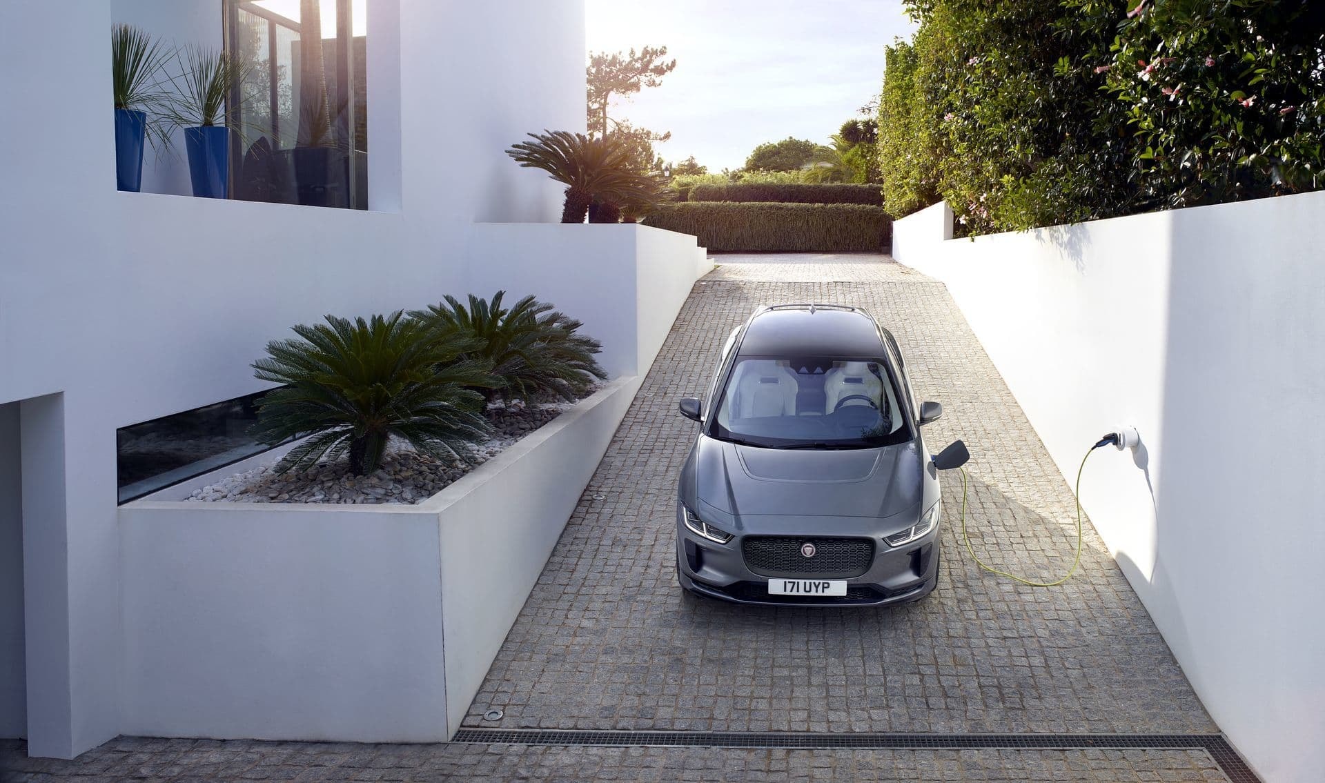 El Jaguar I-Pace mostrando su frente imponente al entrar a una propiedad moderna.