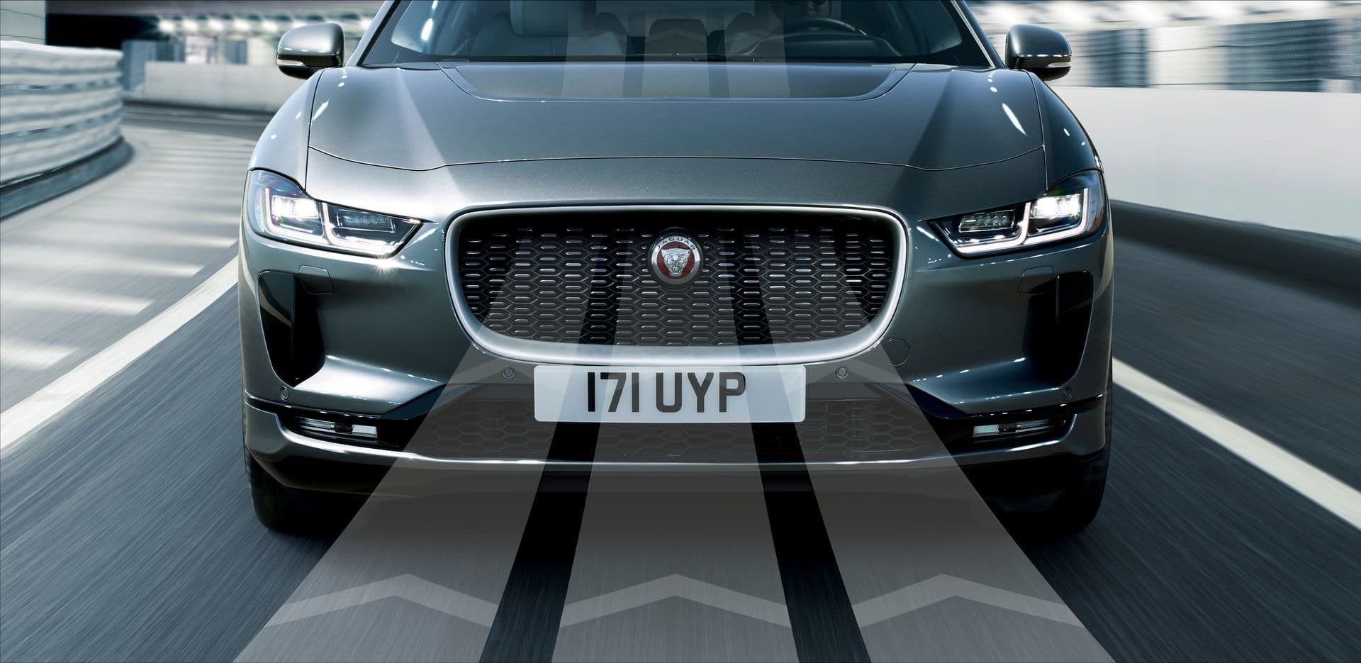 Vista frontal del Jaguar I-Pace en movimiento, destacando su diseño aerodinámico.