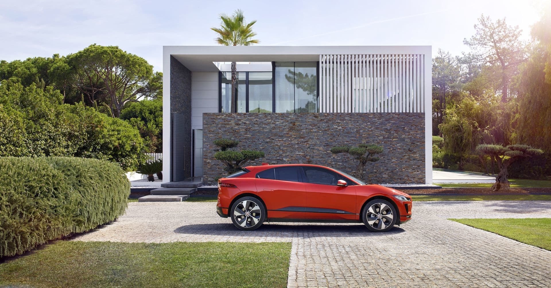 Vista lateral del Jaguar I-Pace en un entorno residencial de lujo.