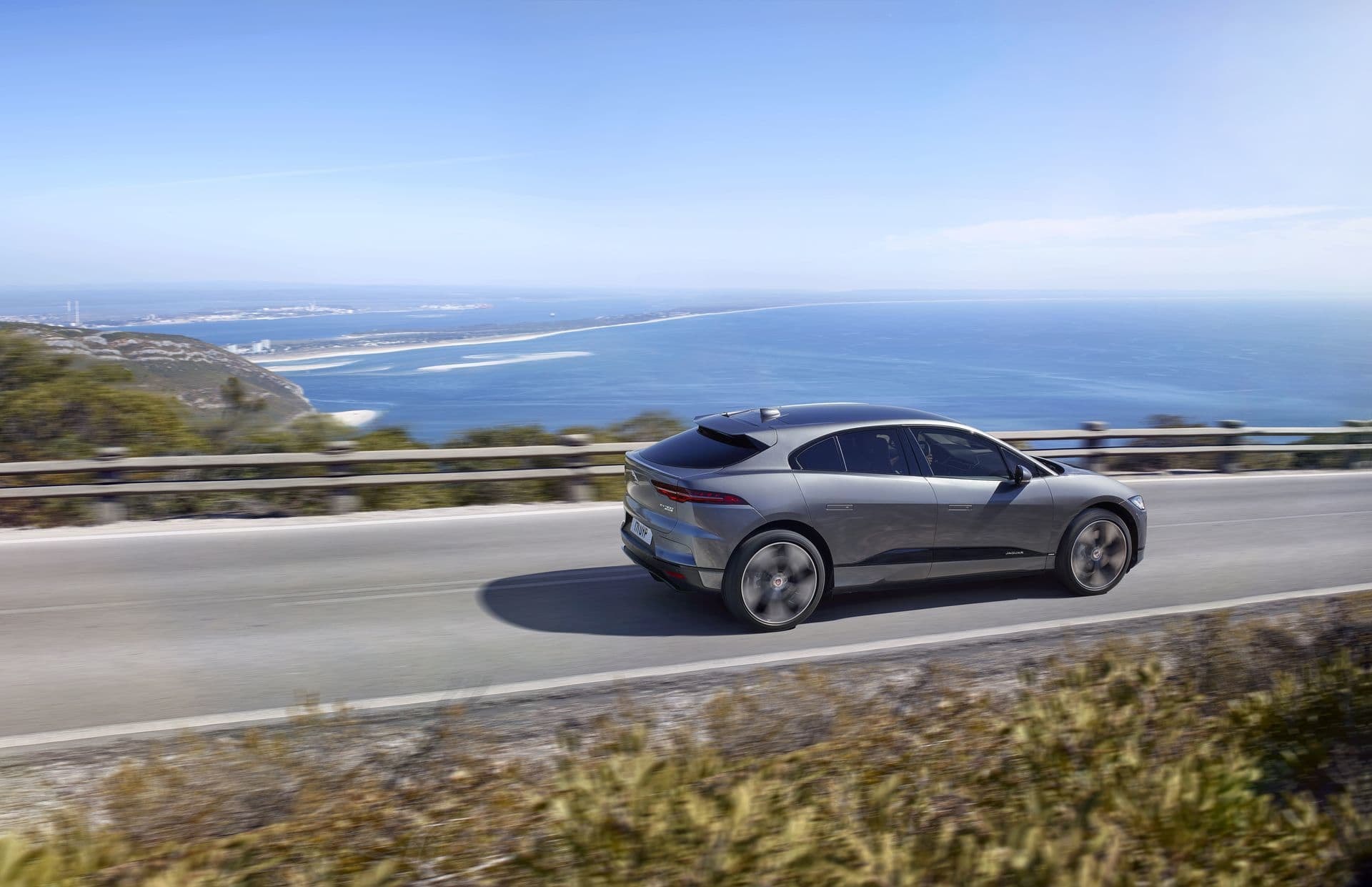 Vista lateral del Jaguar I-Pace en movimiento, con el mar de fondo.