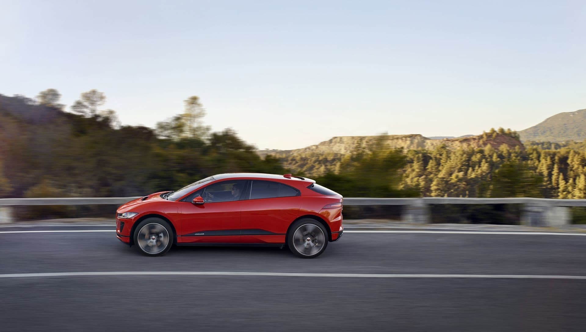 Jaguar I-Pace en color rojo recorriendo una carretera de montaña.