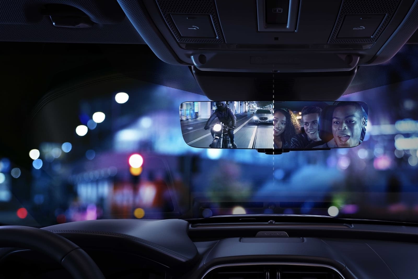 Vista a través del espejo retrovisor interior del Jaguar XE, enfocando la vida nocturna.