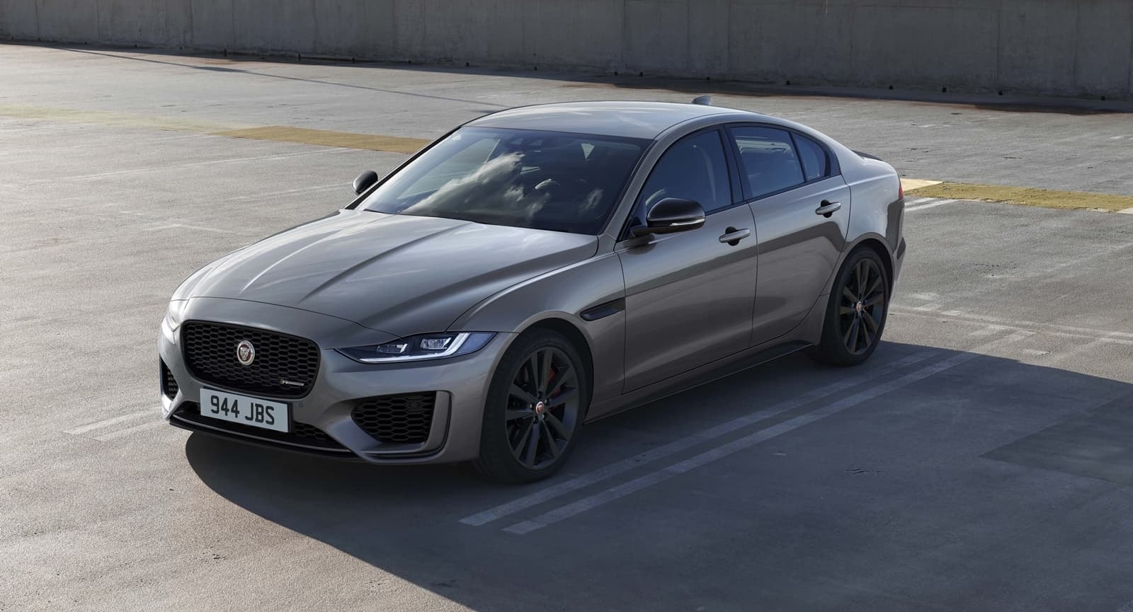 Vista frontal y lateral del Jaguar XE en color gris, reflejando su porte y clase.
