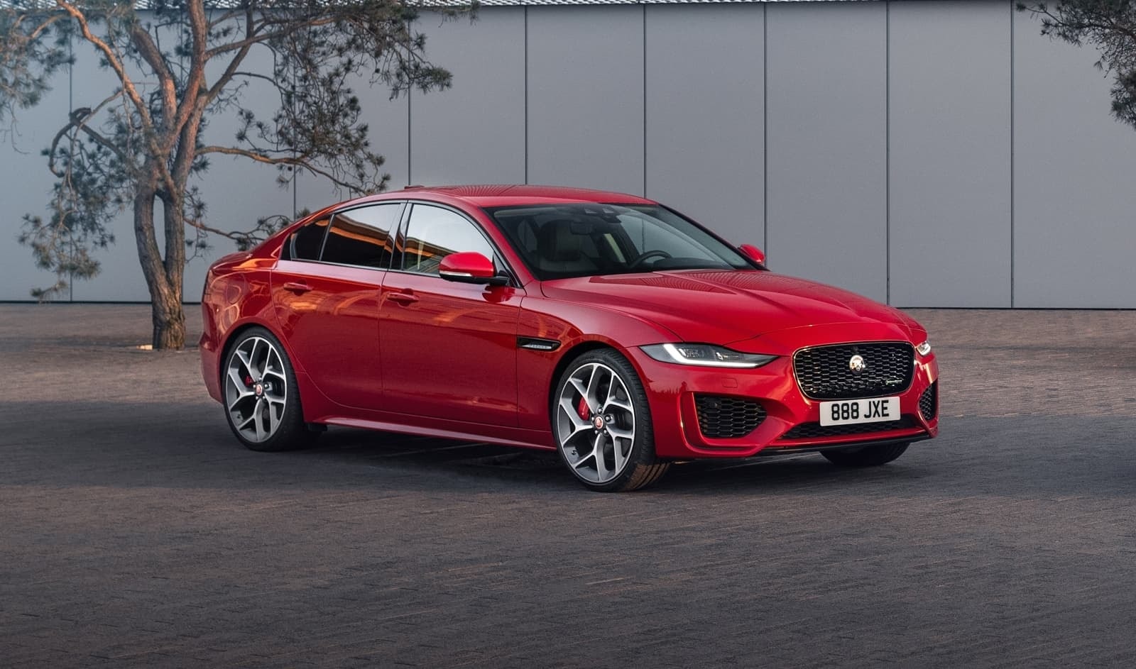 Perfil dinámico del Jaguar XE en color rojo con llantas de diseño deportivo.