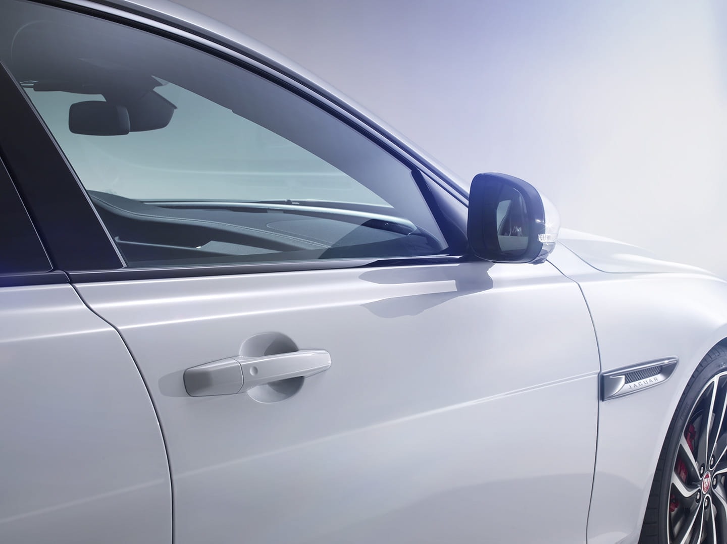 Primer plano del espejo lateral del Jaguar XF, refinamiento y aerodinámica.