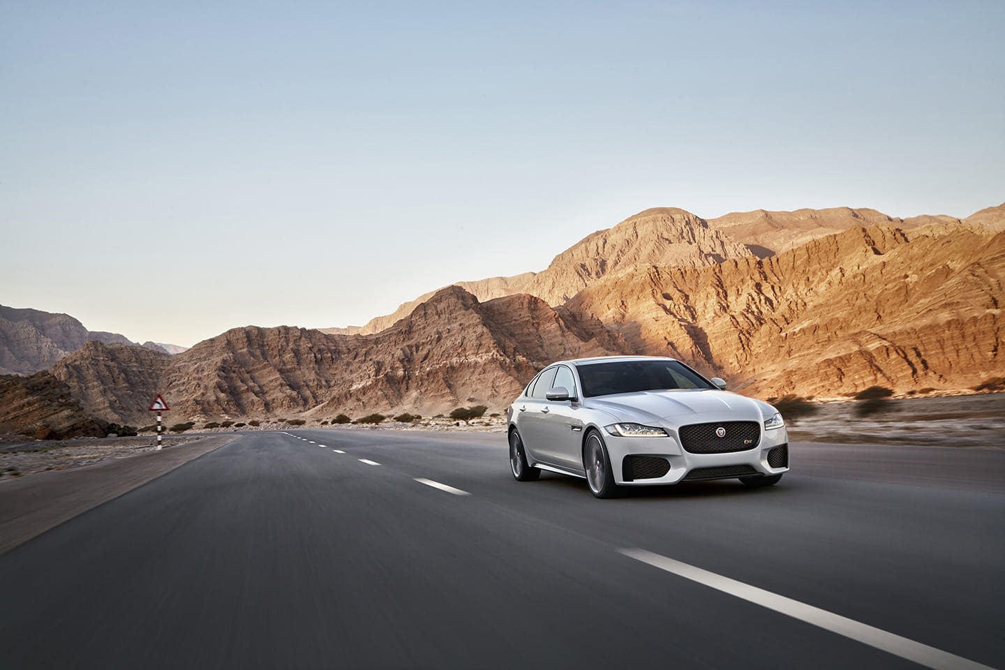 Vista delantera lateral del Jaguar XF en carretera, mostrando la parrilla y faros distintivos.