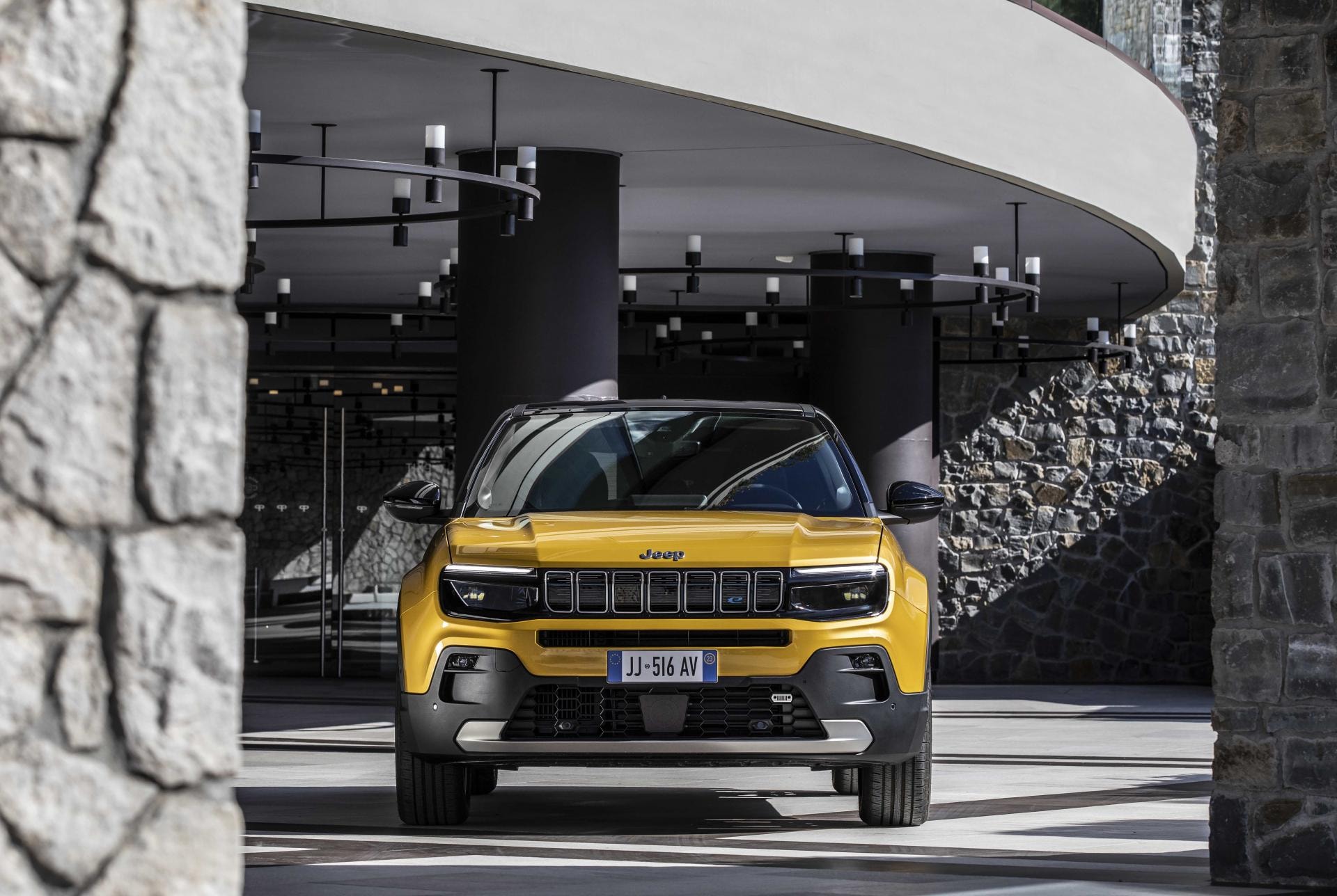 El Jeep Avenger presentado con una fachada arquitectónica moderna como fondo.