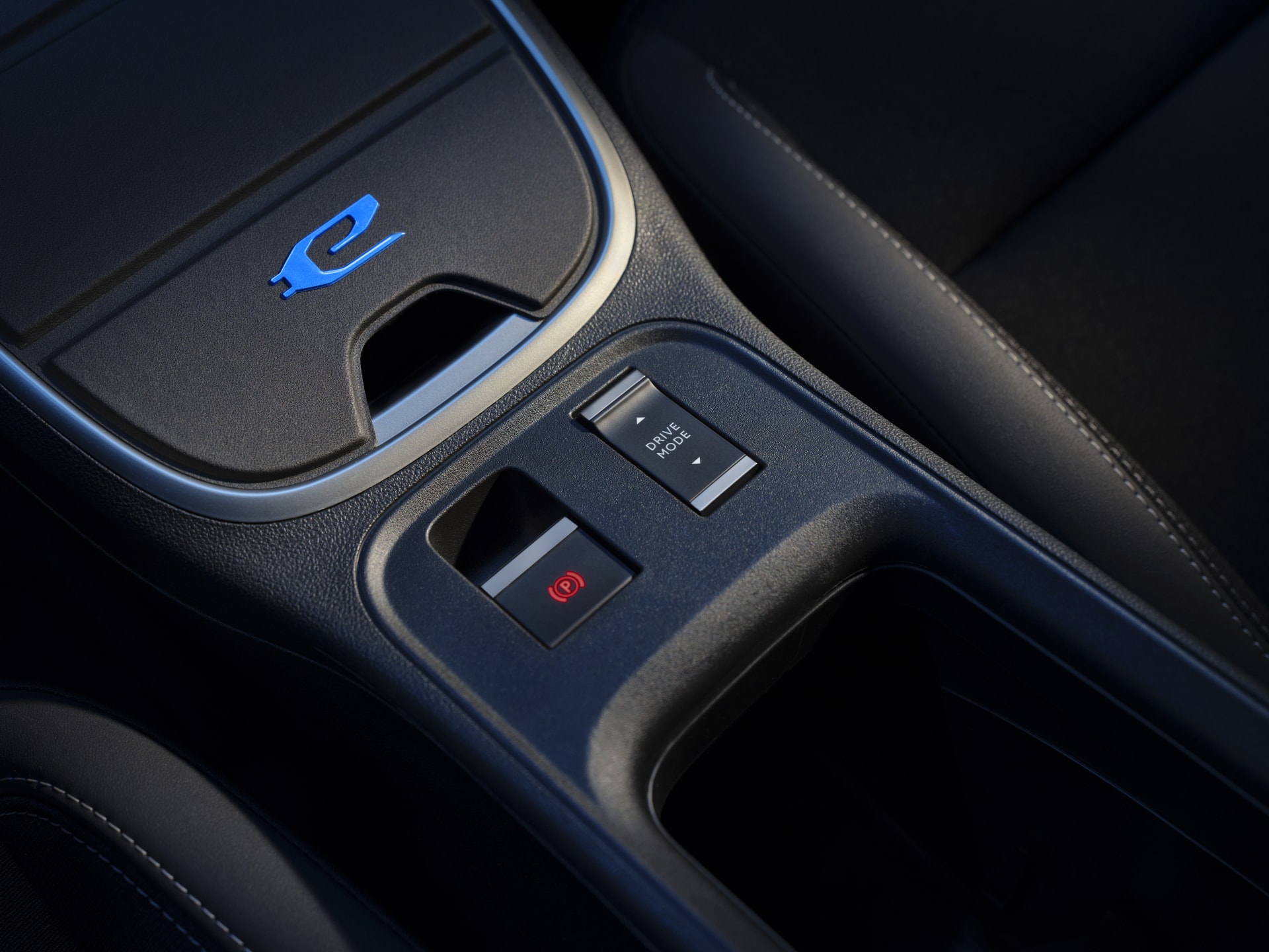 Toma cercana de la consola central, enfocando en los controles y el cargador inalámbrico.