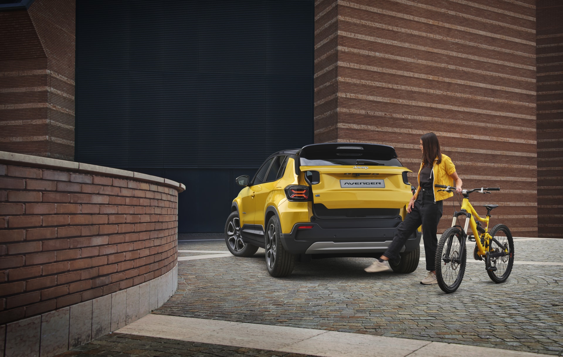 El Jeep Avenger eléctrico con el maletero abierto cargando una bicicleta.