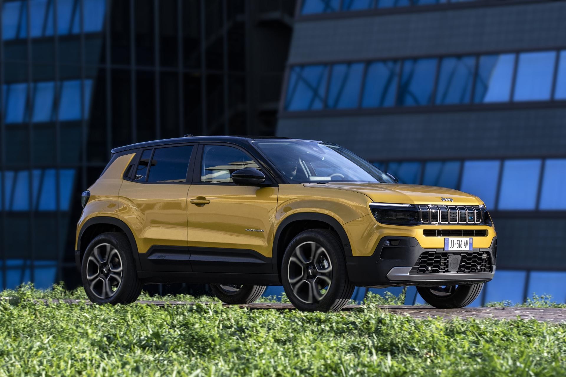 Jeep Avenger eléctrico perfilado contra un entorno urbano, mostrando su diseño.