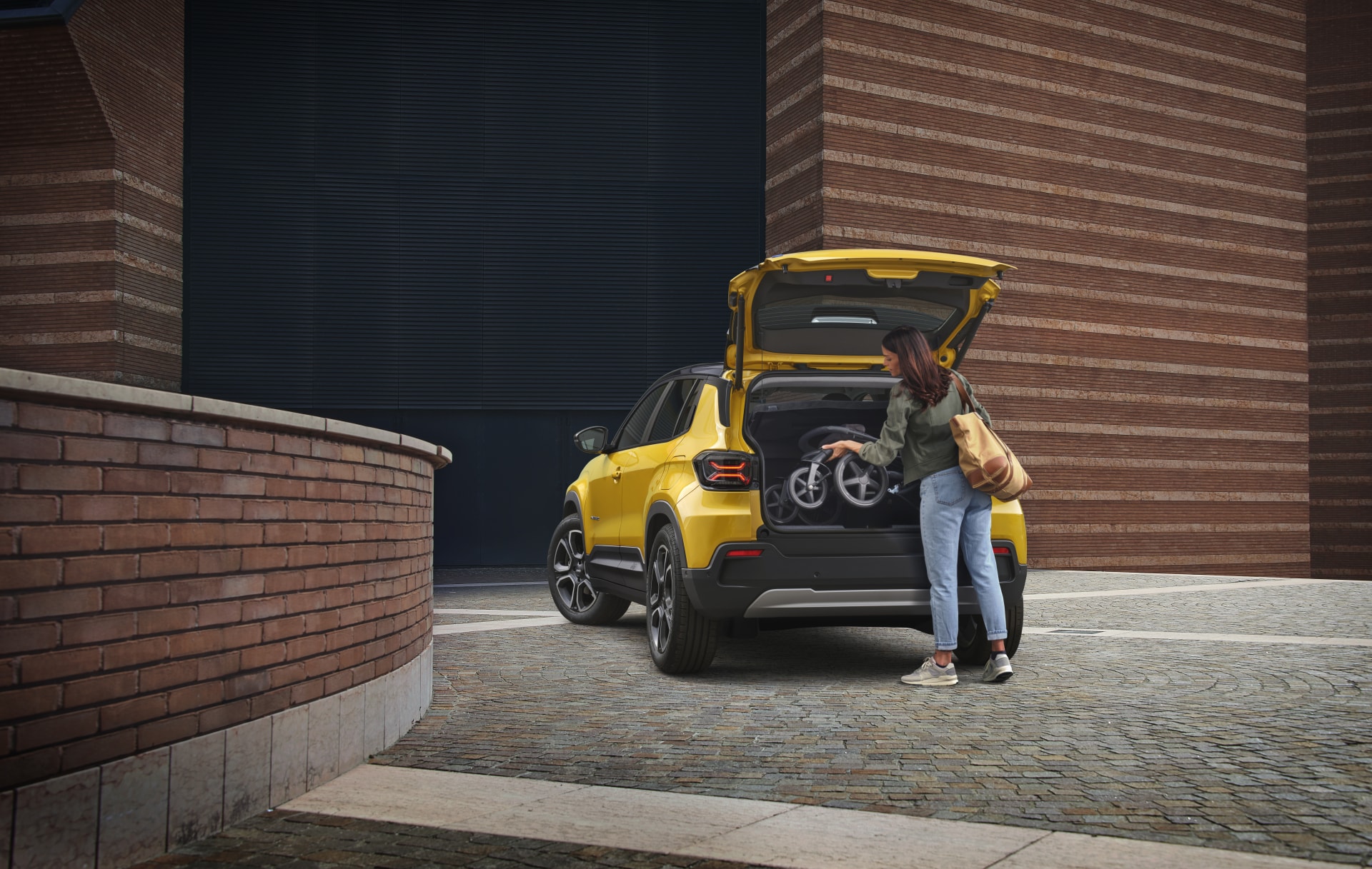 Accesibilidad al maletero del Jeep Avenger eléctrico con usuario preparando equipaje.