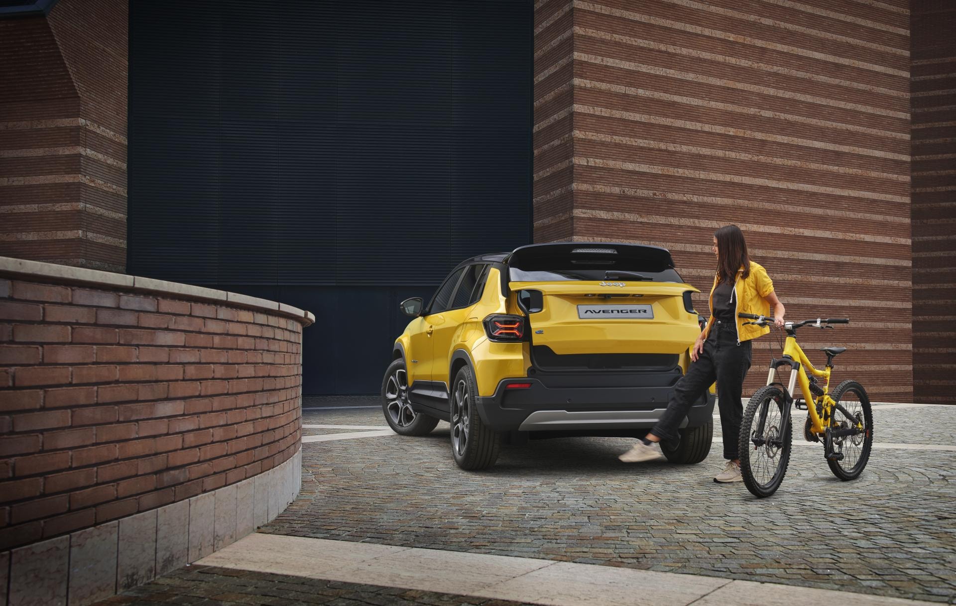 Vista trasera del Jeep Avenger eléctrico en un entorno urbano, resaltando su diseño.