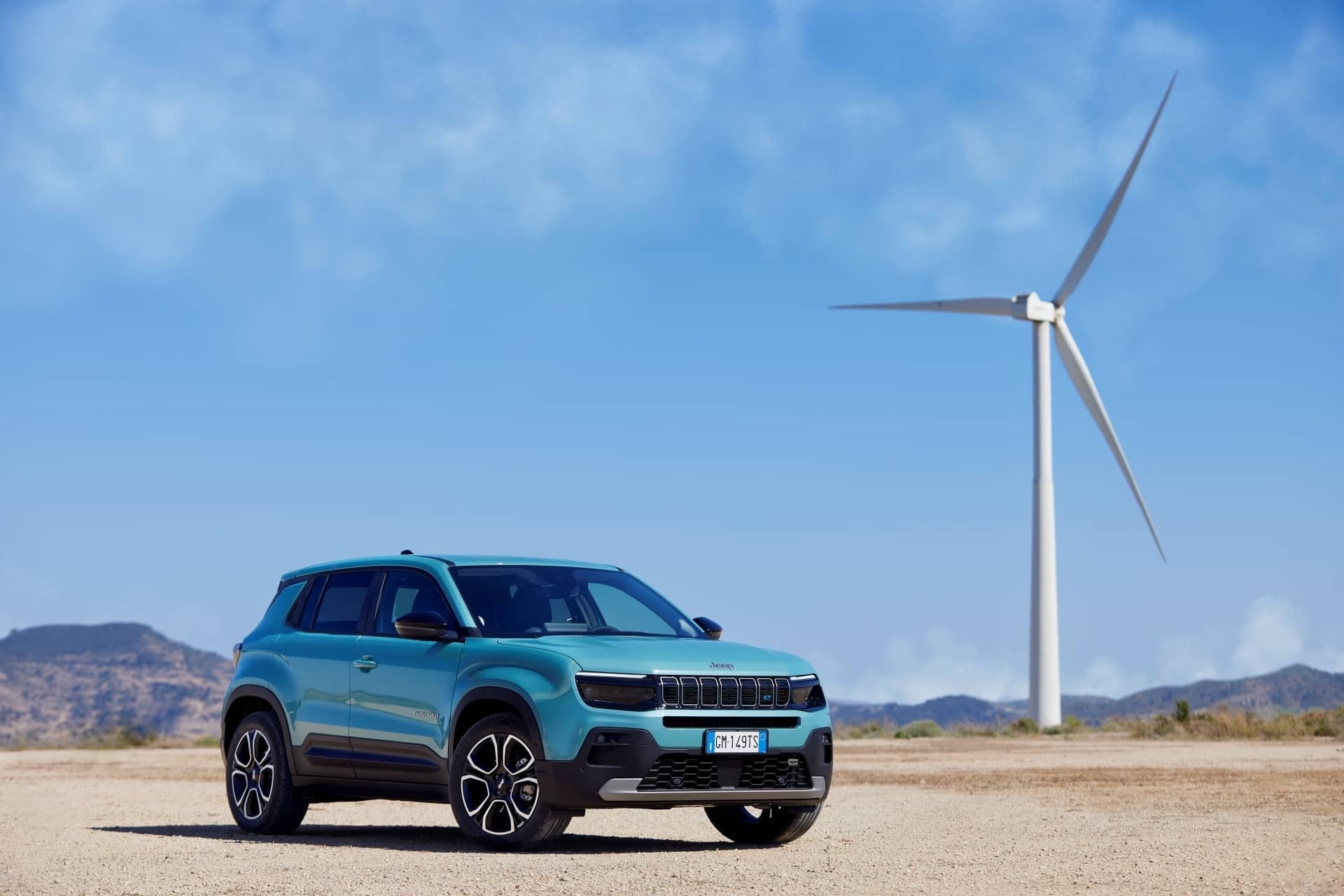 Jeep Avenger frente a parque eólico, simbolizando compromiso con sostenibilidad.