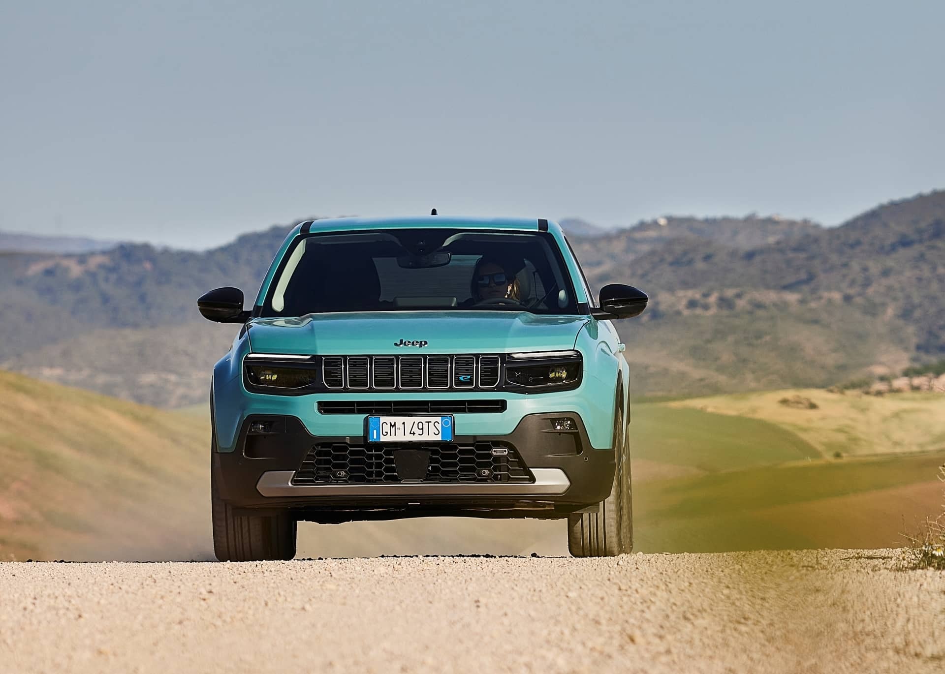 Vista frontal del Jeep Avenger en carretera campestre.