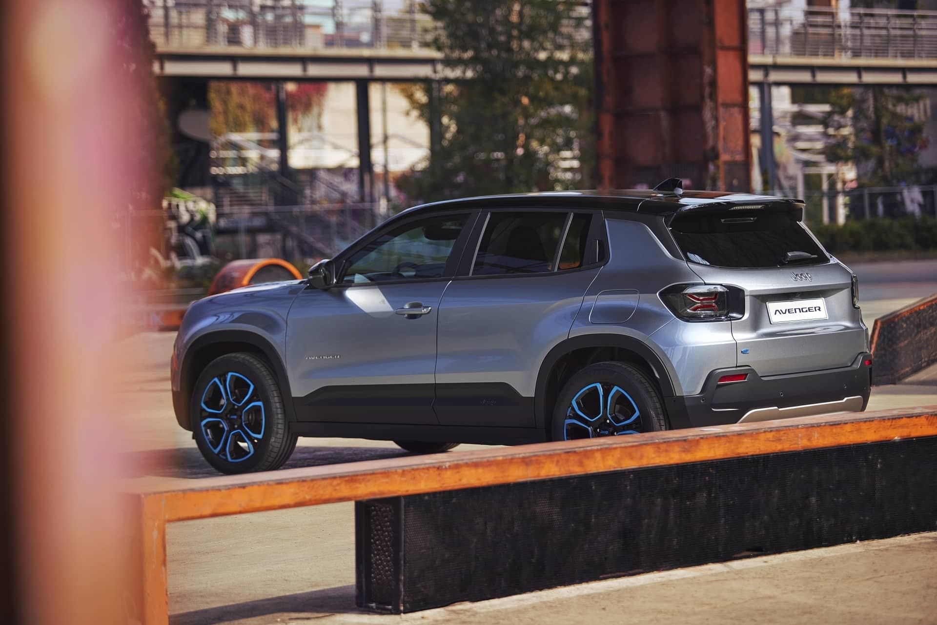 Jeep Avenger estacionado en un entorno industrial, destacando su diseño lateral.