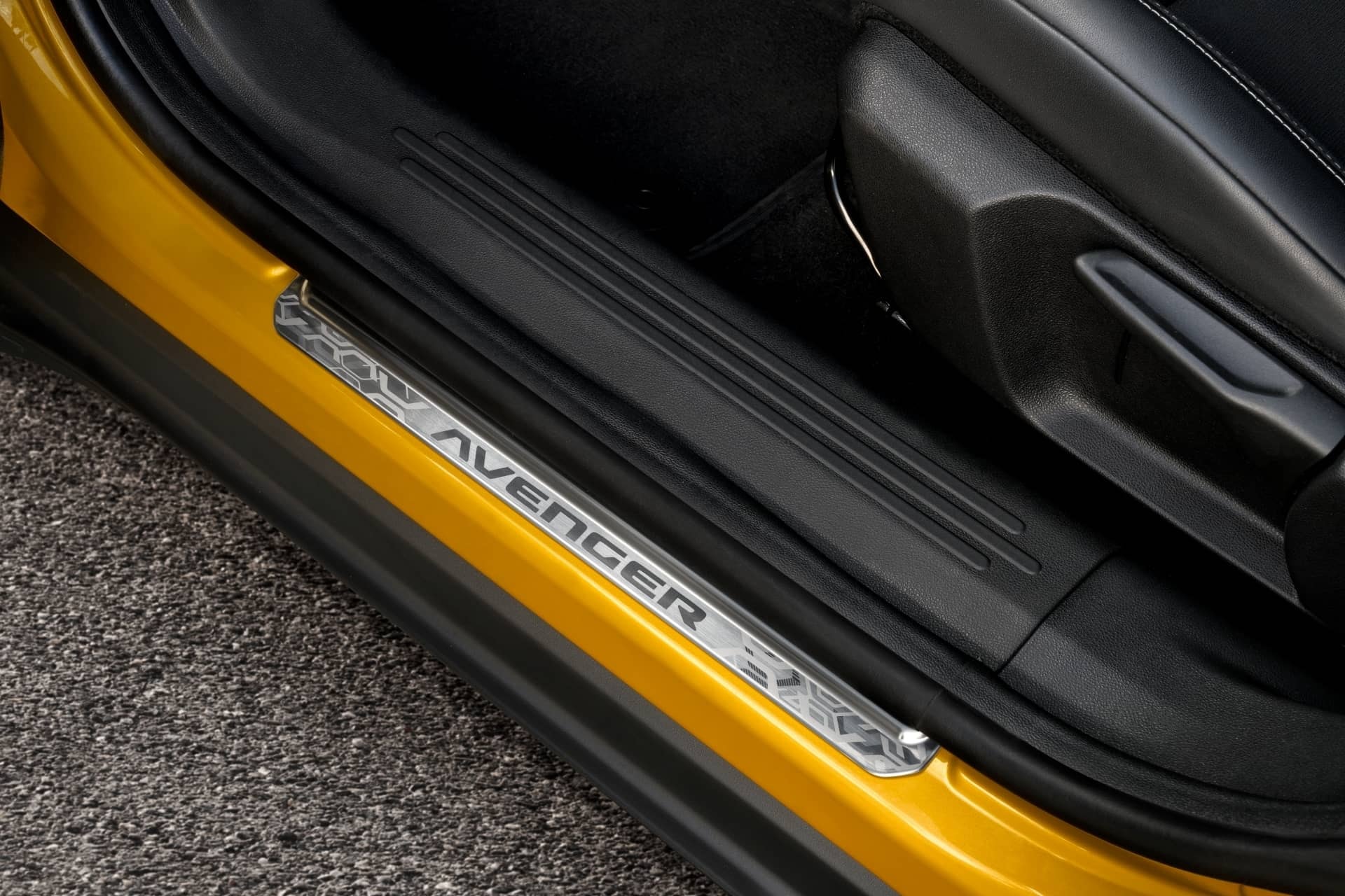 Detalle del umbral de la puerta con insignia Avenger iluminada.