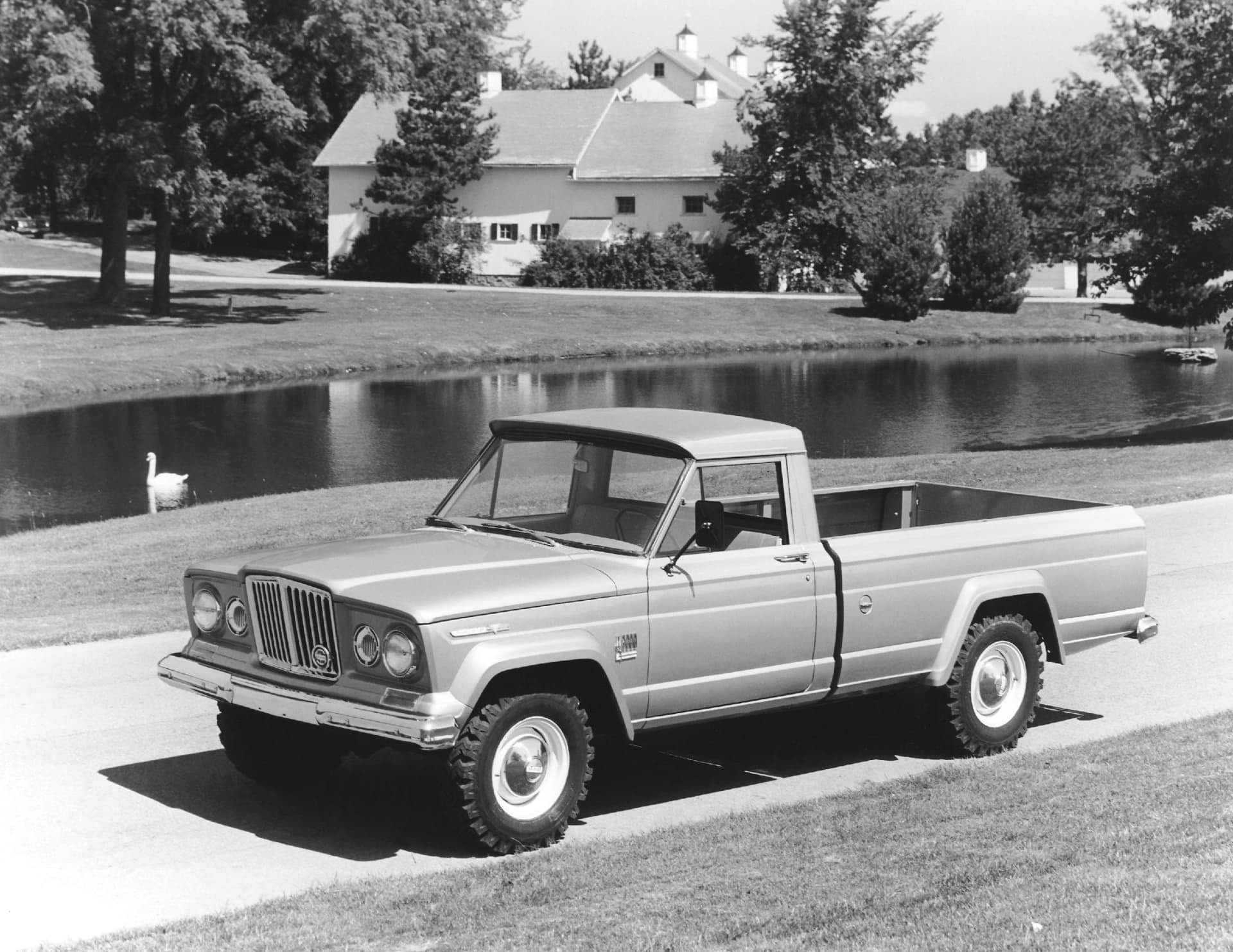 Imagen en blanco y negro de un Jeep Gladiator clásico frente a campo verde