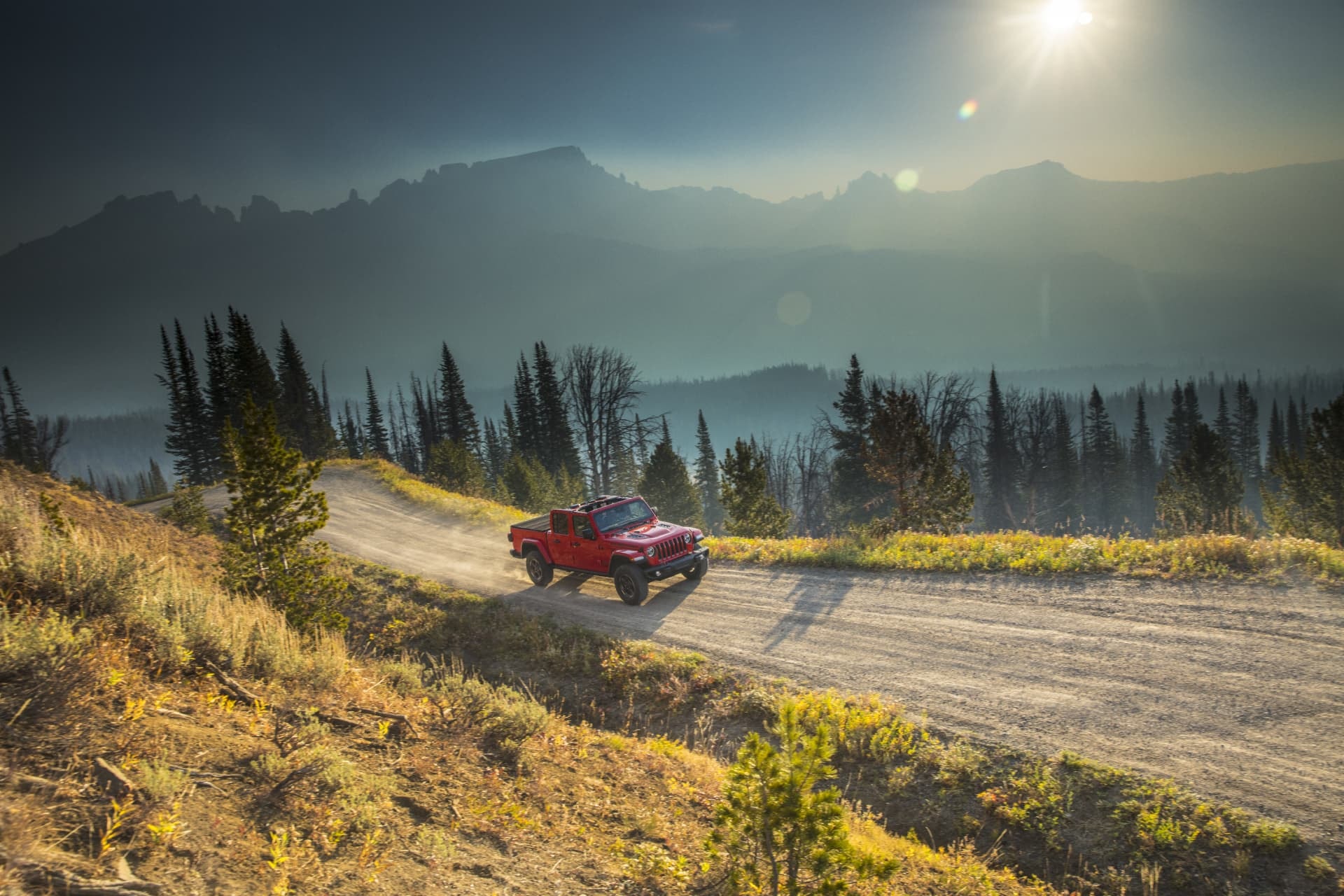 Jeep Gladiator dominando terrenos montañosos al atardecer.