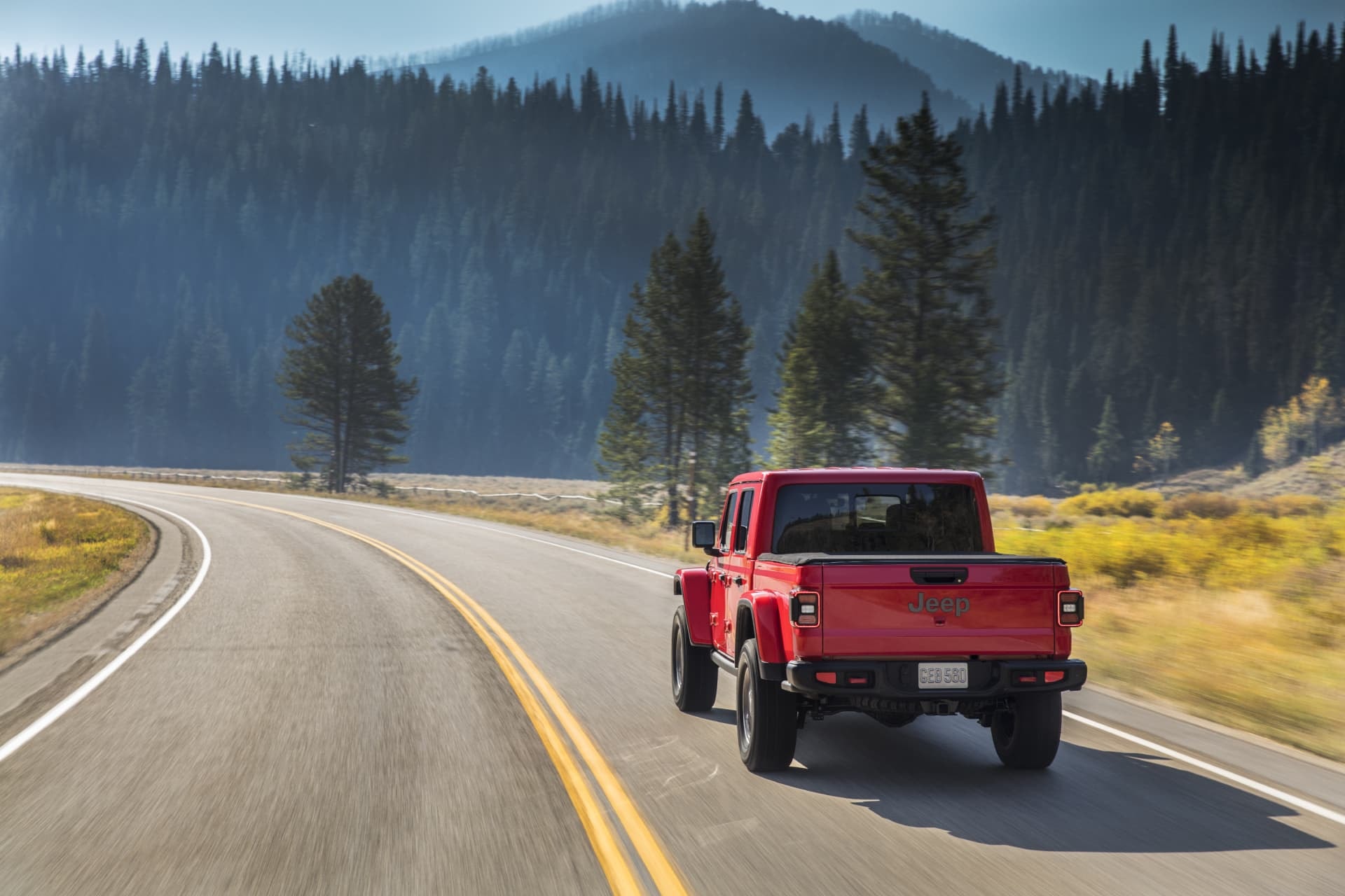 Vista dinámica del Jeep Gladiator recorriendo una carretera de montaña.