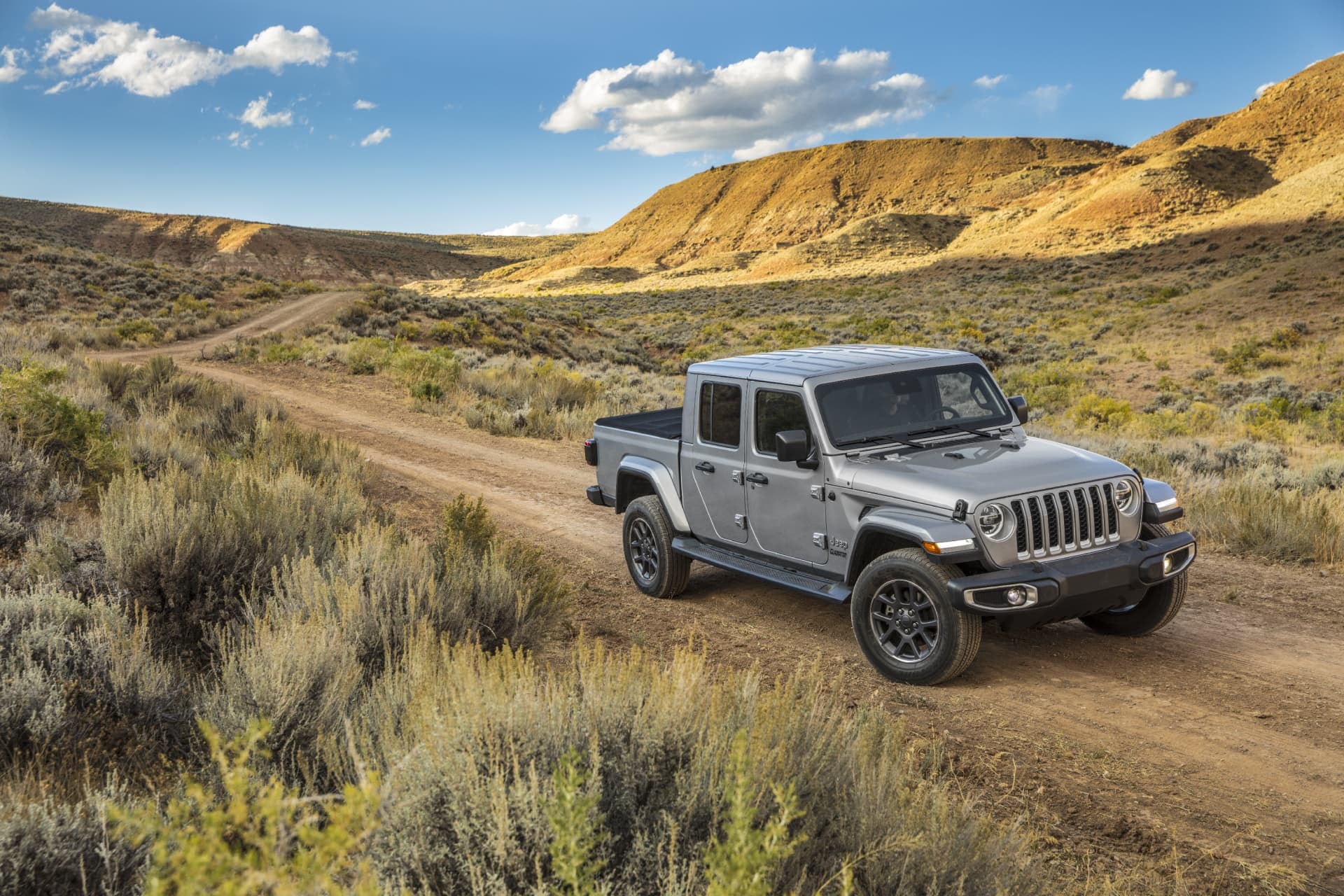 Jeep Gladiator gris en un entorno natural, mostrando su perfil lateral.