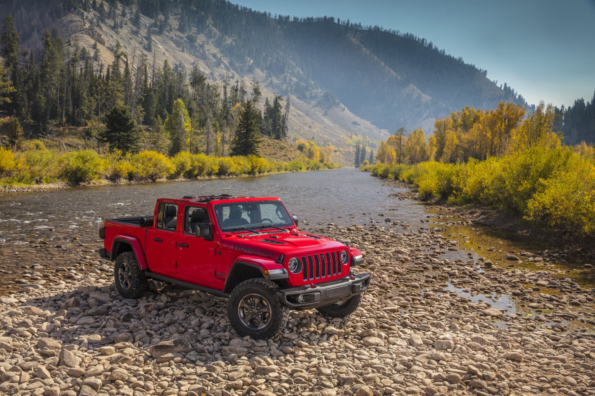 Perfil del Jeep Gladiator rojo en escenario natural, ensalzando su adaptabilidad.