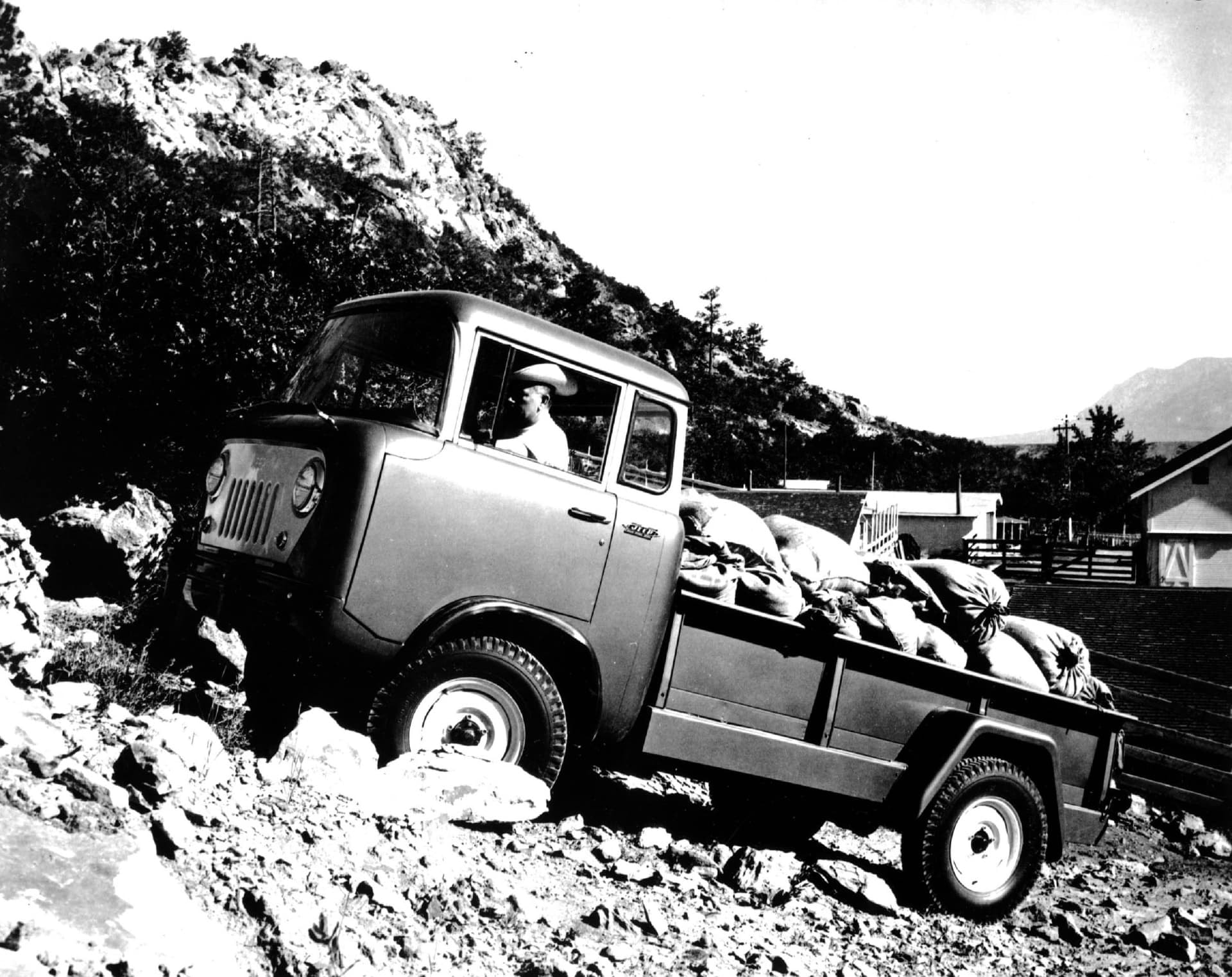 Imagen en blanco y negro del ancestro del Gladiator, el Willys Pickup trabajando duro.