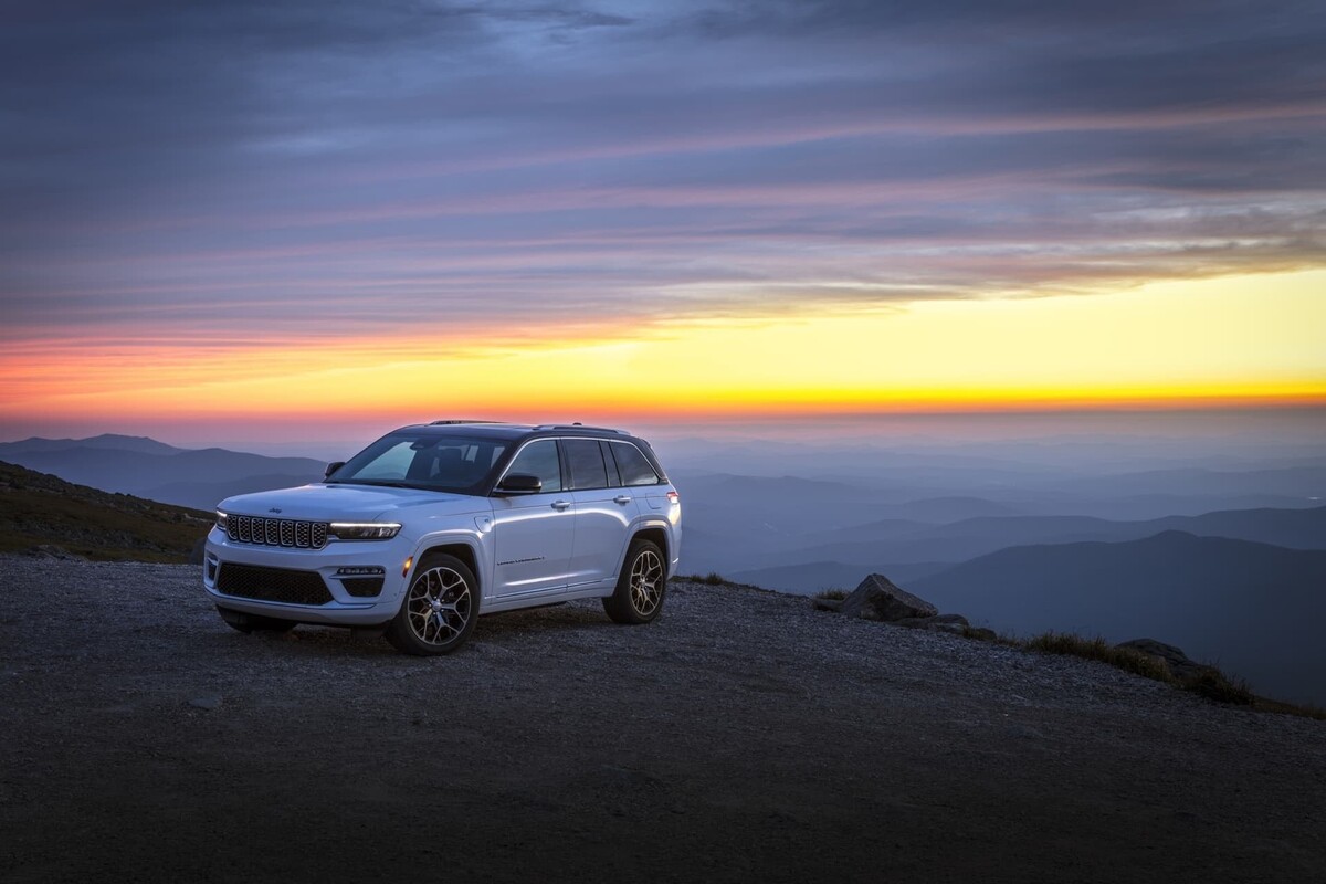Perfil lateral del Jeep Grand Cherokee en un escenario de montañas. Perfil lateral del Jeep Grand Cherokee en un escenario de montañas.