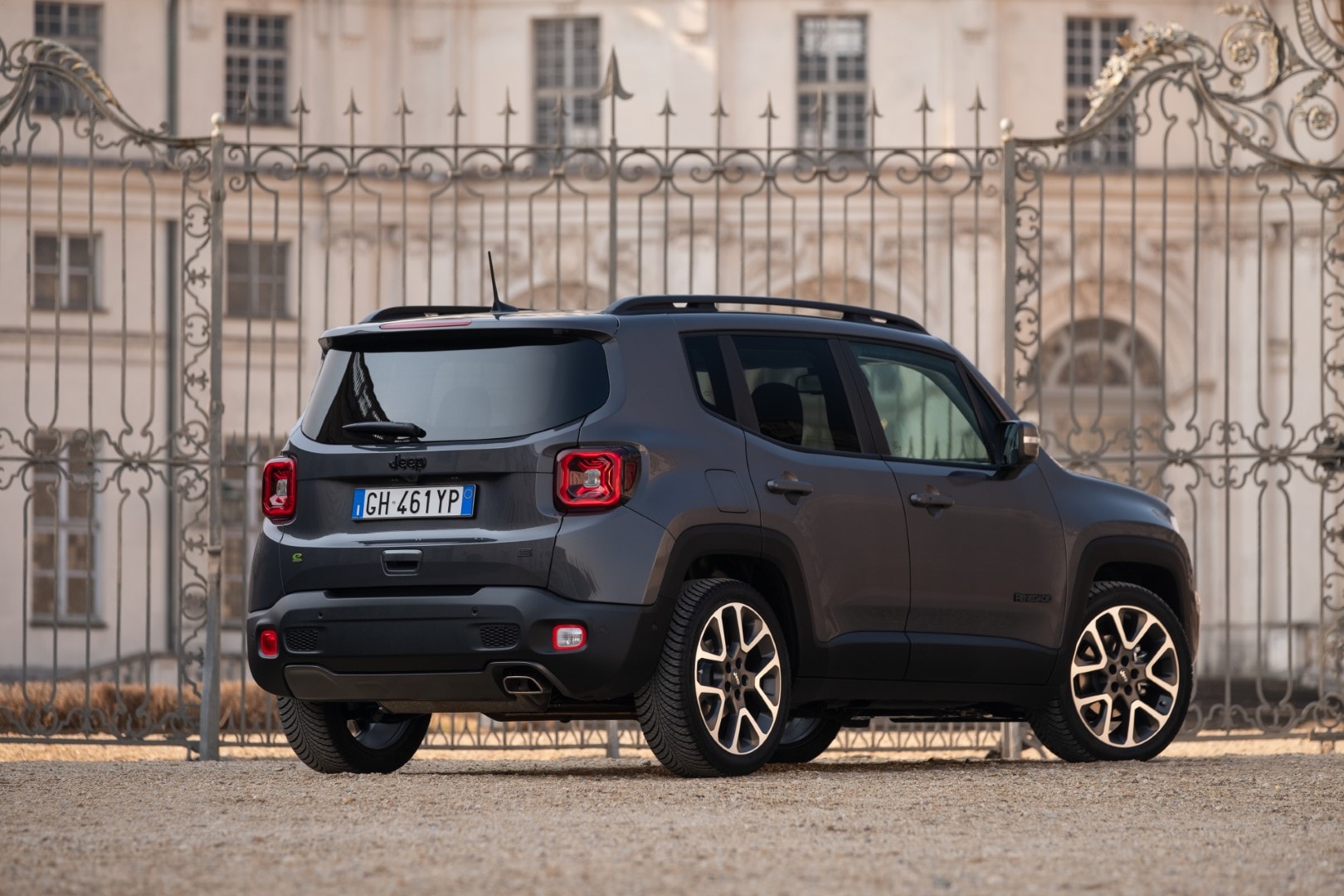 Visión trasera completa del Jeep Renegade híbrido estacionado ante rejas ornamentadas