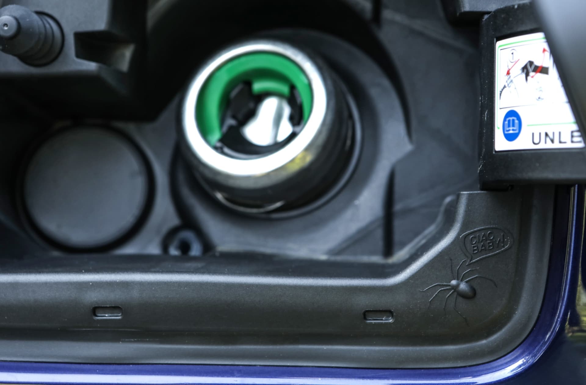 Detalle de la tapa de combustible con aviso de gasolina.
