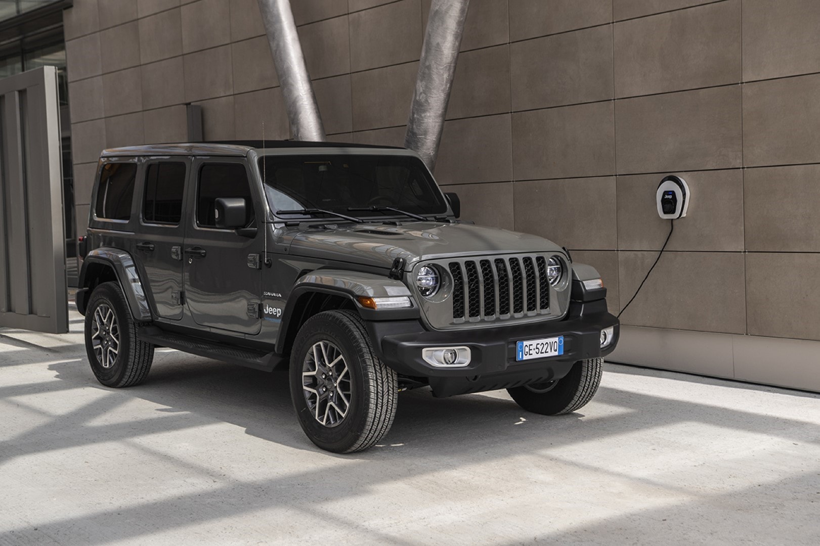 Jeep Wrangler Híbrido conectado a un cargador en un entorno urbano.