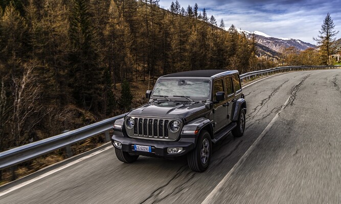 Jeep Wrangler Híbrido recorriendo una carretera de montaña. Jeep Wrangler Híbrido recorriendo una carretera de montaña.