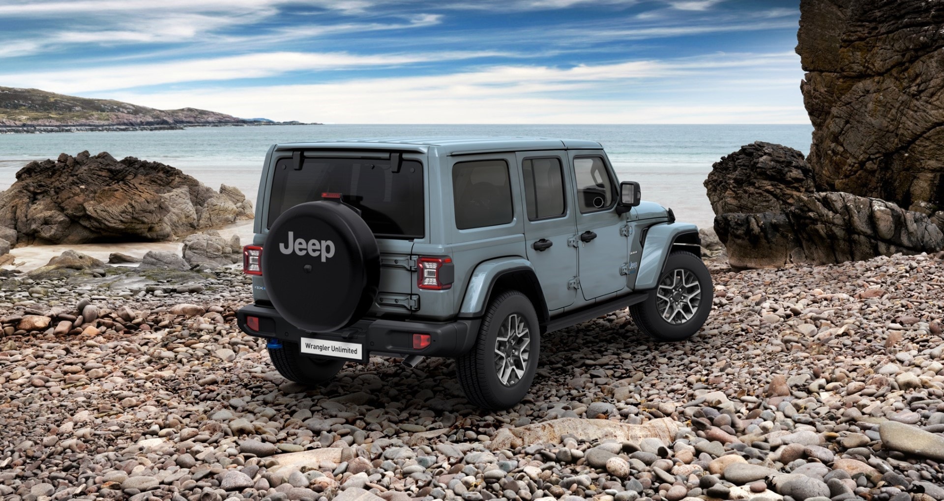 Vista trasera del Jeep Wrangler híbrido aparcado en una costa rocosa.