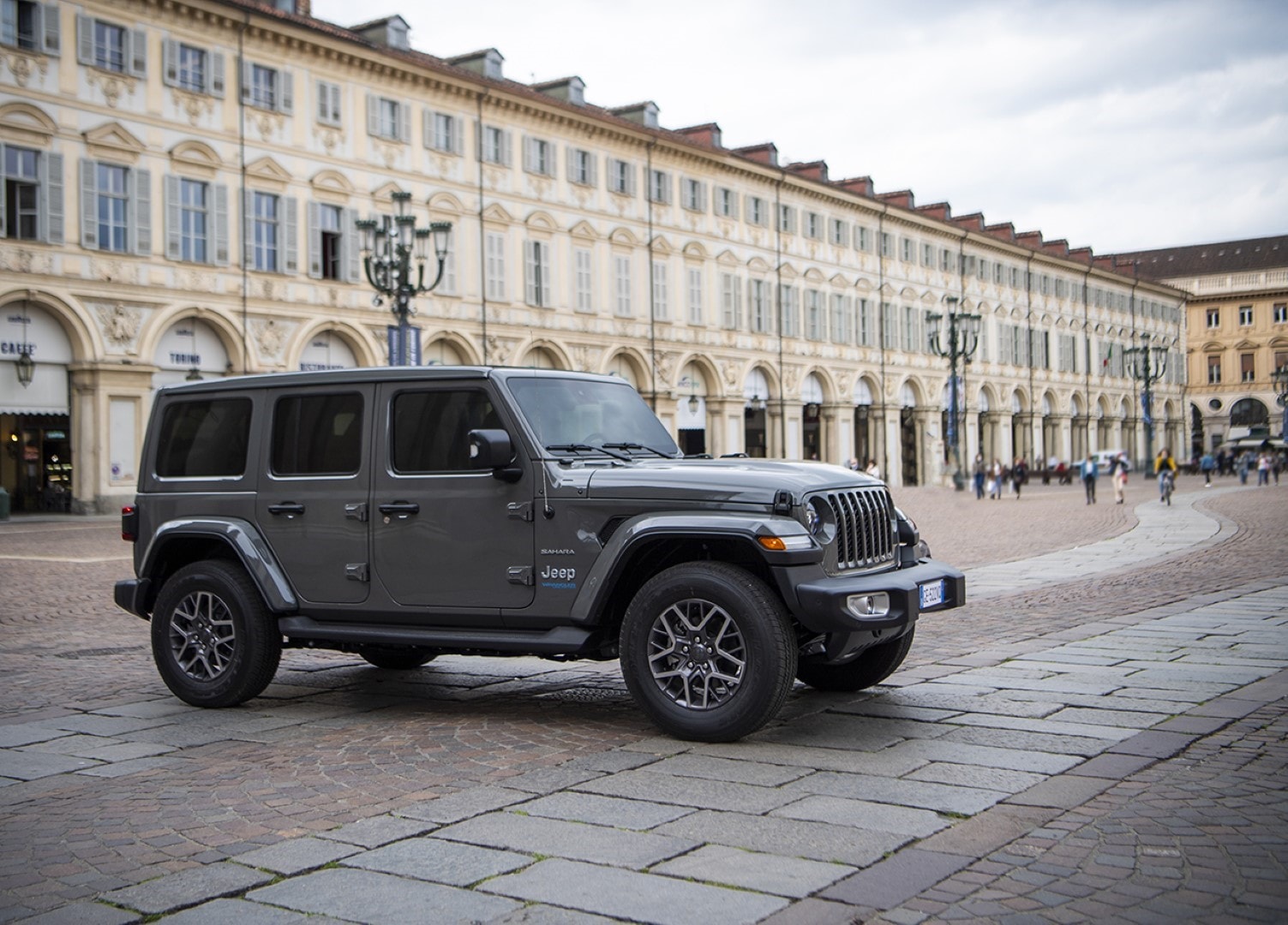 Fotografía del Jeep Wrangler híbrido en una plaza urbana, combinando historia y tecnología moderna.