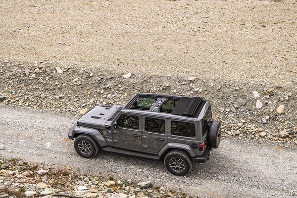 Vista aérea del Jeep Wrangler Híbrido en terreno abierto, destacando su techo. Vista aérea del Jeep Wrangler Híbrido en terreno abierto, destacando su techo.