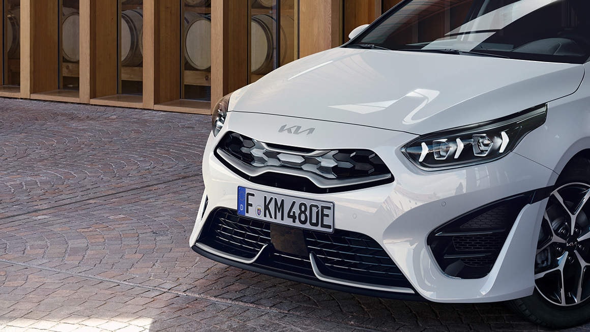 Primer plano del diseño frontal del Kia Ceed Tourer, enfocando en la parrilla y ópticas modernas.