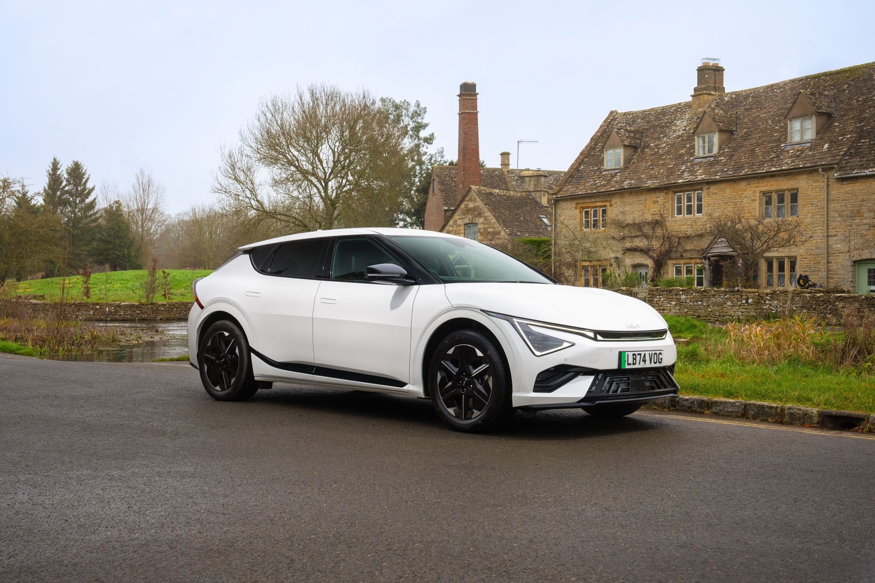 Kia EV6 blanco en un camino, mostrando su diseño futurista desde atrás.