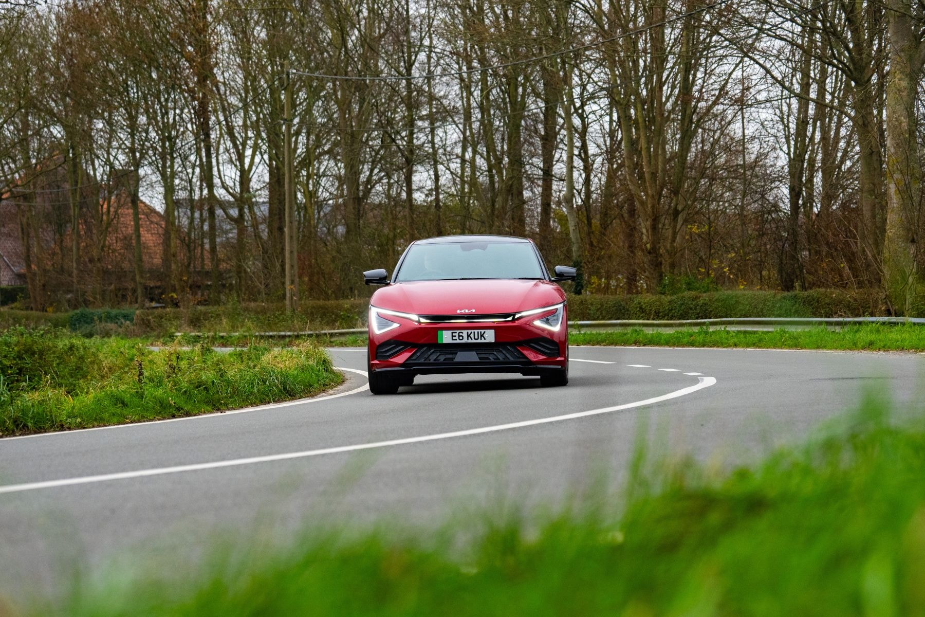 Kia EV6 rojo en acción en carreteras rurales, mostrando su dinamismo.