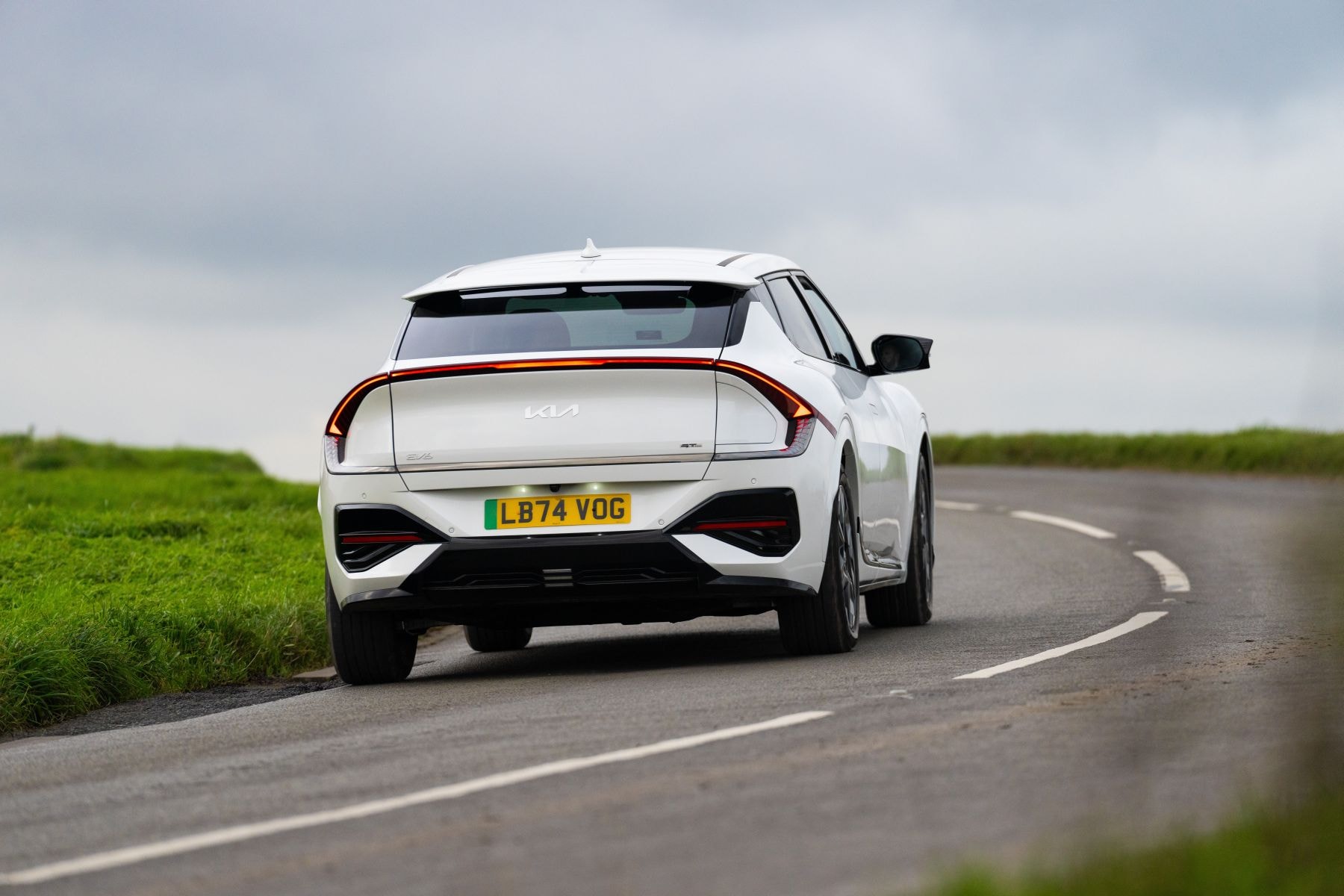 Kia EV6 rojo frente a un fondo moderno, destacando su frontal agresivo.