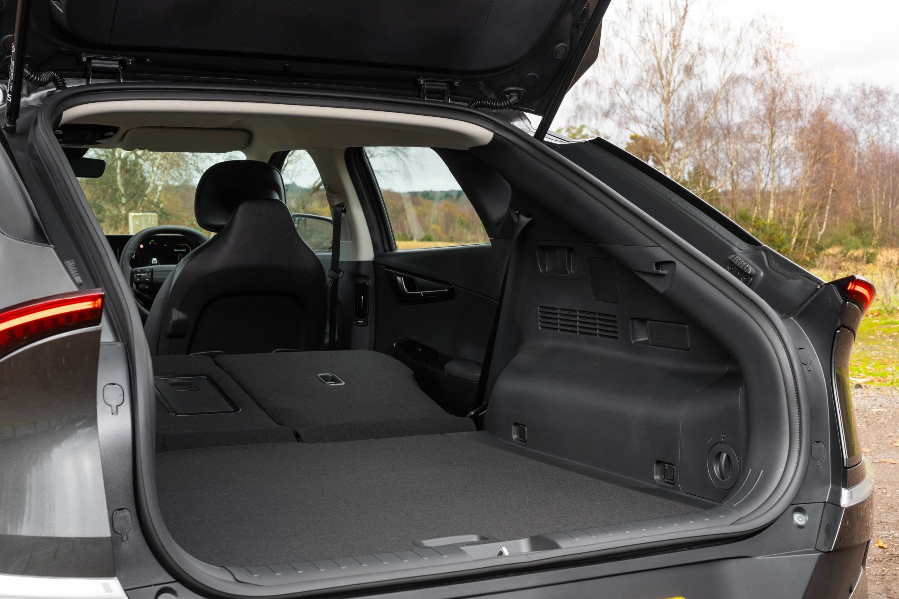 Kia EV6 rojo posado sobre grava, un espectáculo visual audaz.