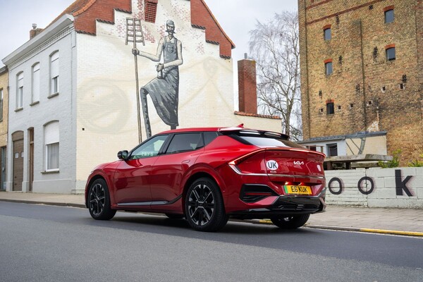 Kia EV6 rojo en una curva, destacando su postura y elegancia. Kia EV6 rojo en una curva, destacando su postura y elegancia.