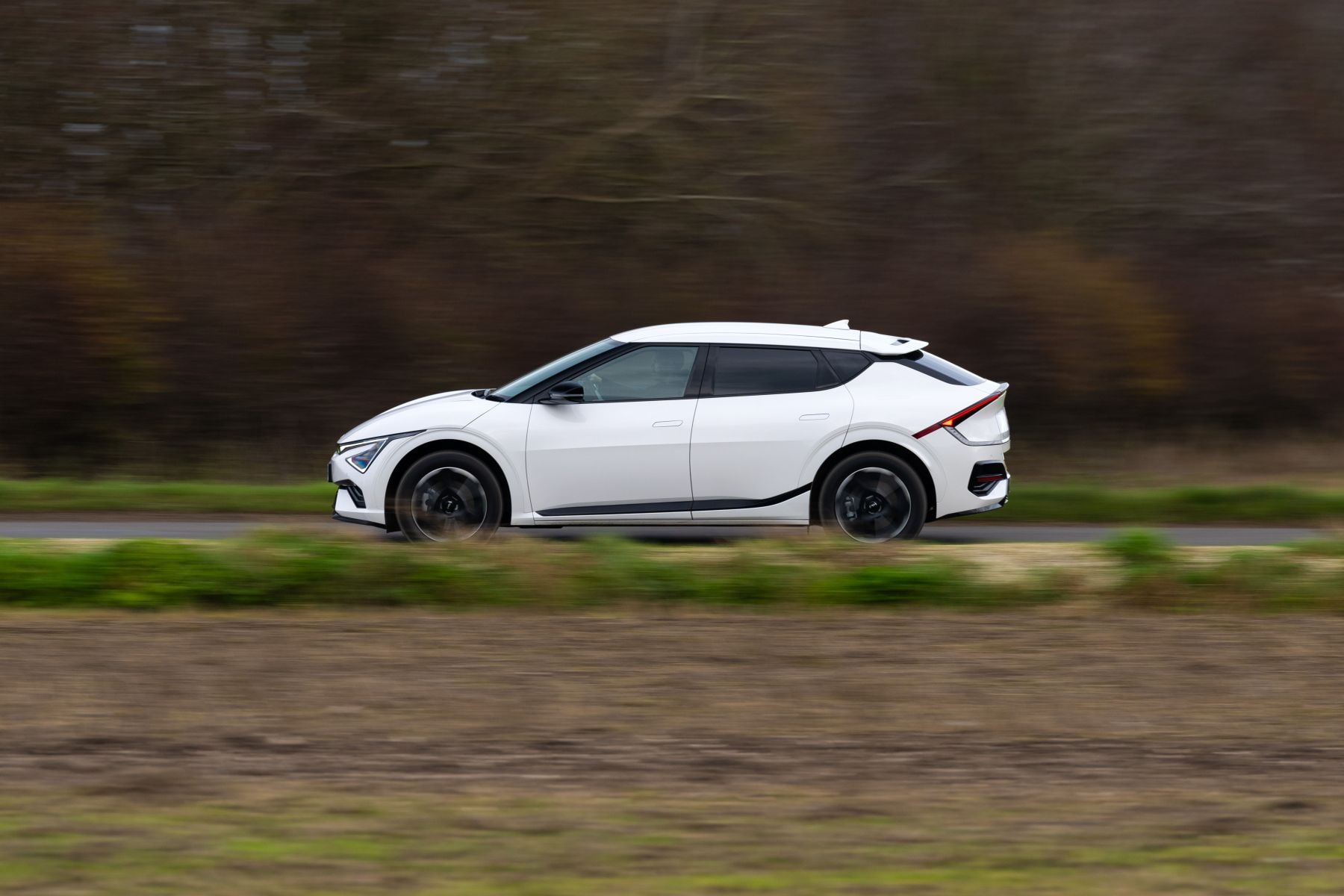 Vista lateral del Kia EV6 en un entorno natural, mostrando su diseño aerodinámico.