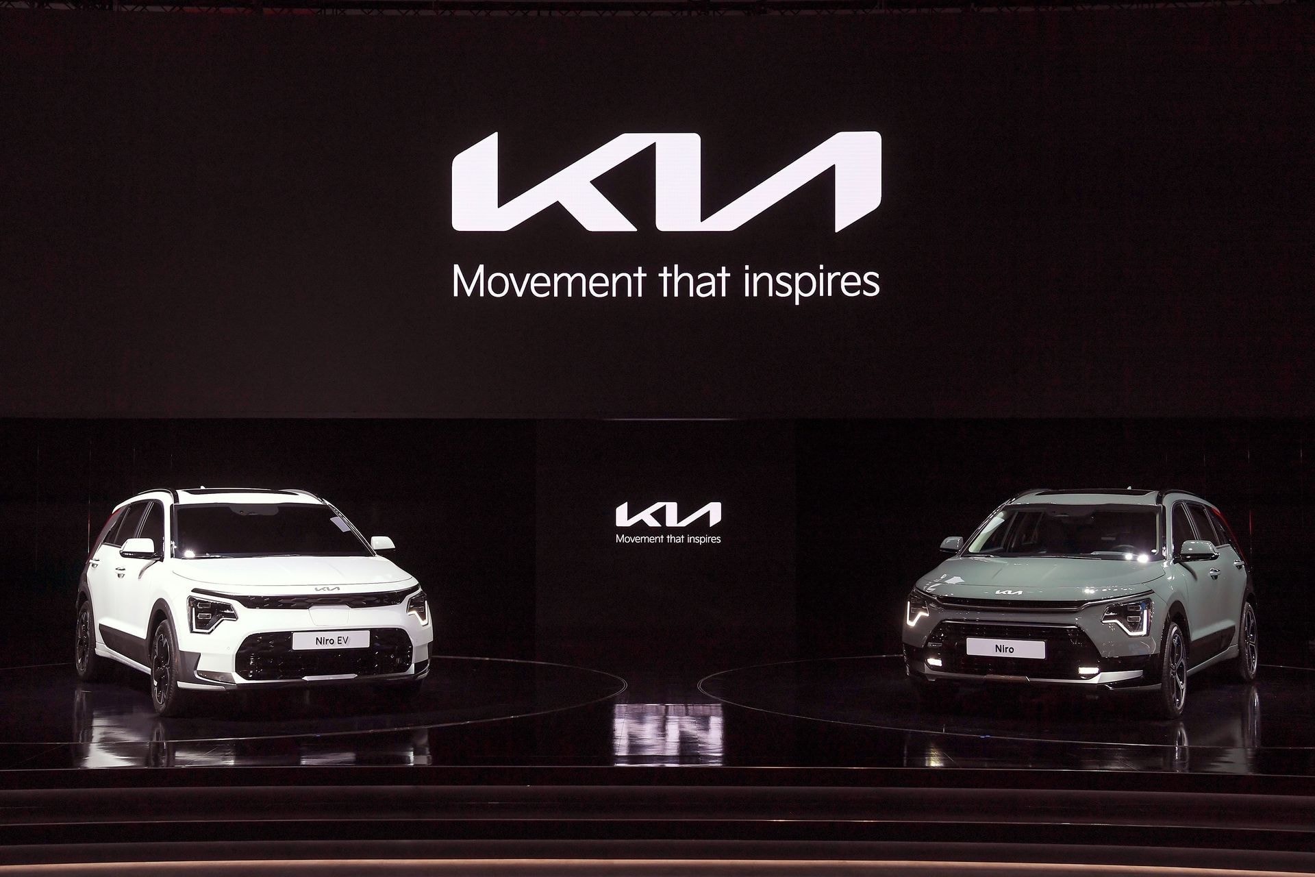 Dos variantes del Kia Niro en escenario de presentación, visión frontal y trasera.