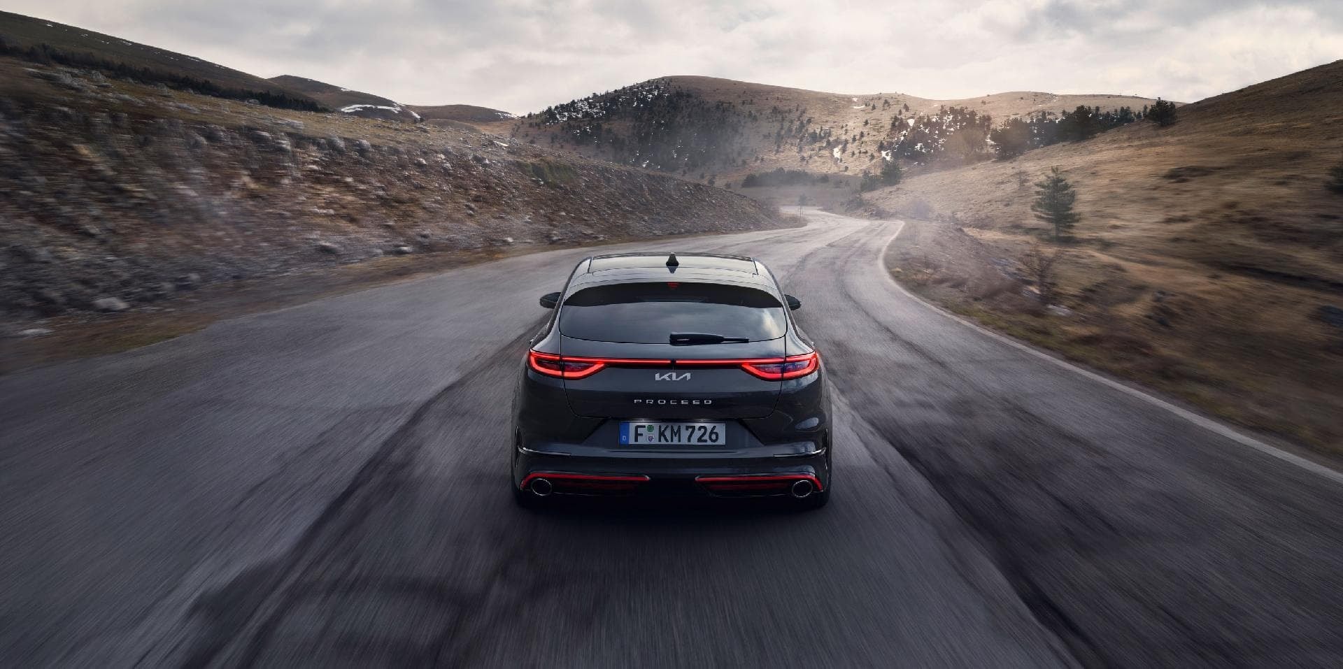 Perspectiva trasera del Kia Proceed en carretera, enfatiza su dinamismo.