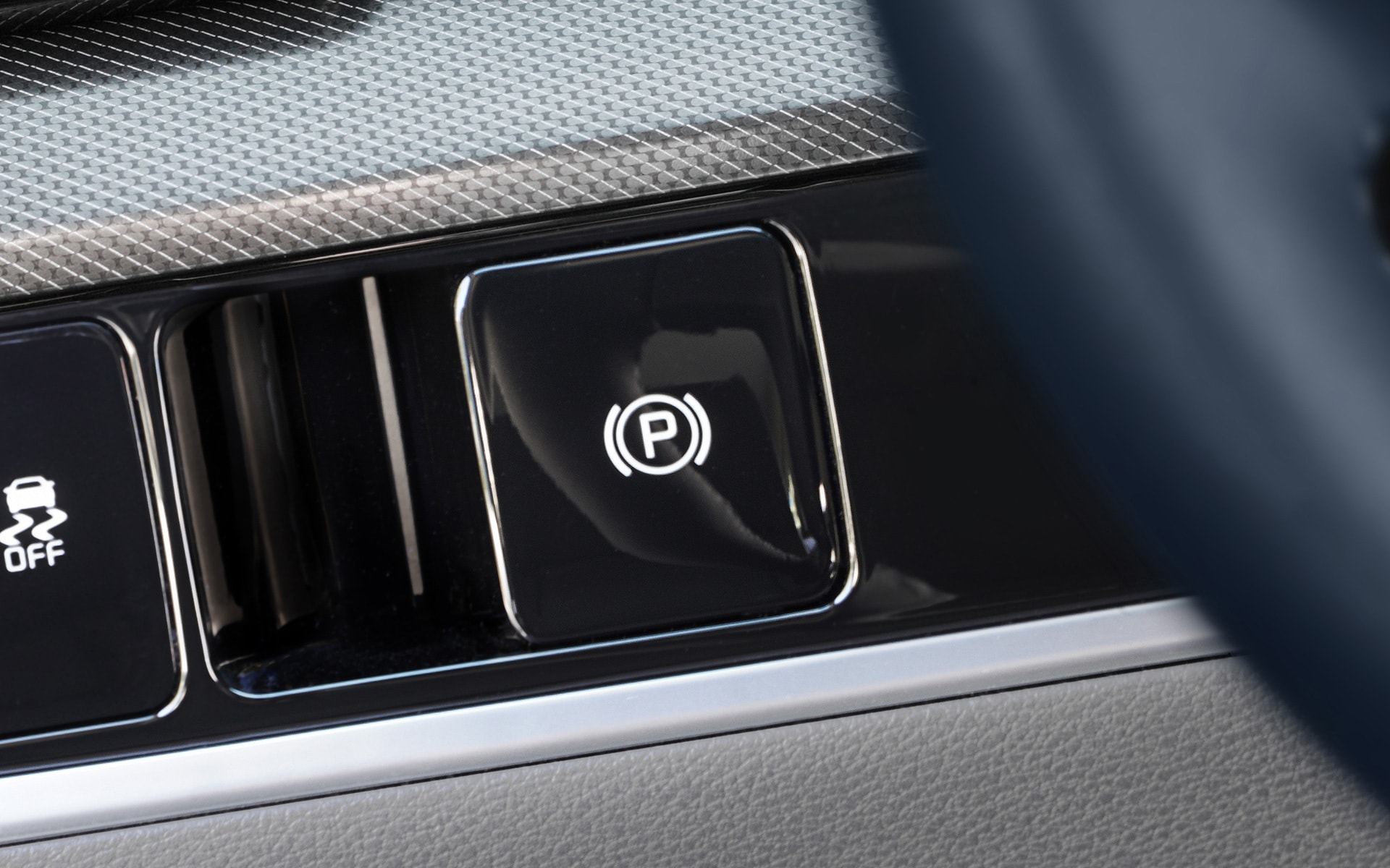 Detalle del botón de freno de estacionamiento electrónico.