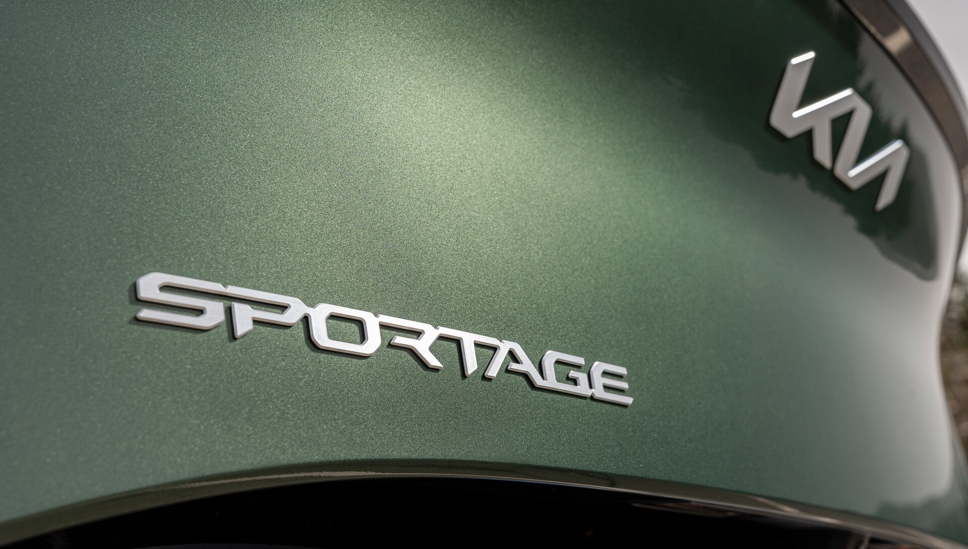 Enfoque del emblema "Sportage" en la parte trasera del vehículo.