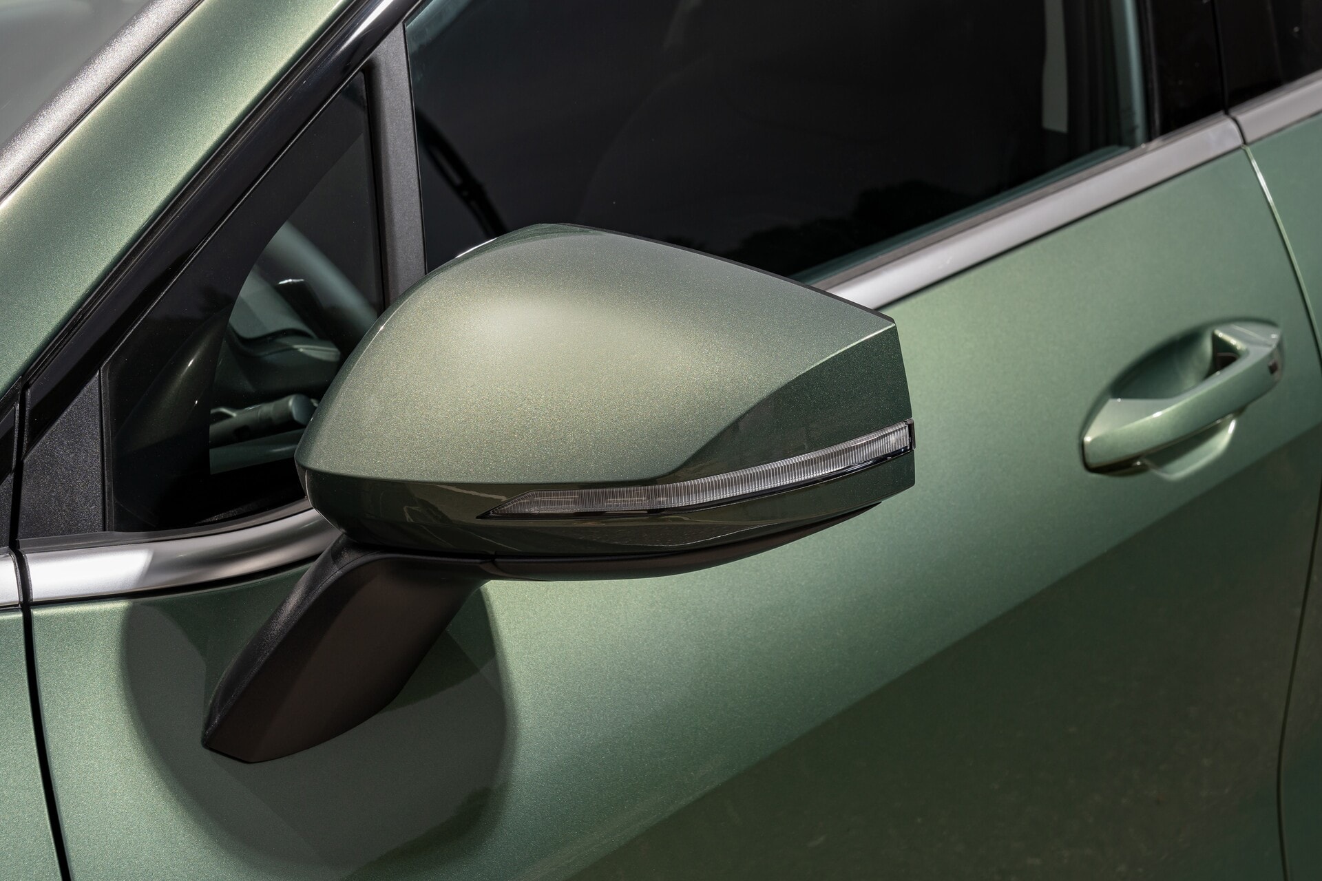 Primer plano del retrovisor exterior con acabados cromados.