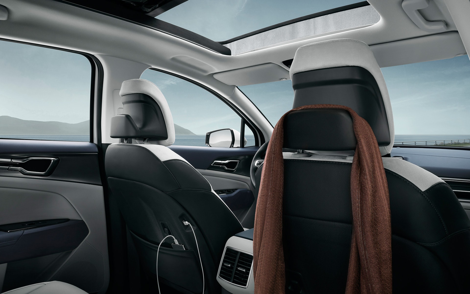 Imagen del lujoso interior del Kia Sportage híbrido, destacando los asientos y el techo solar.