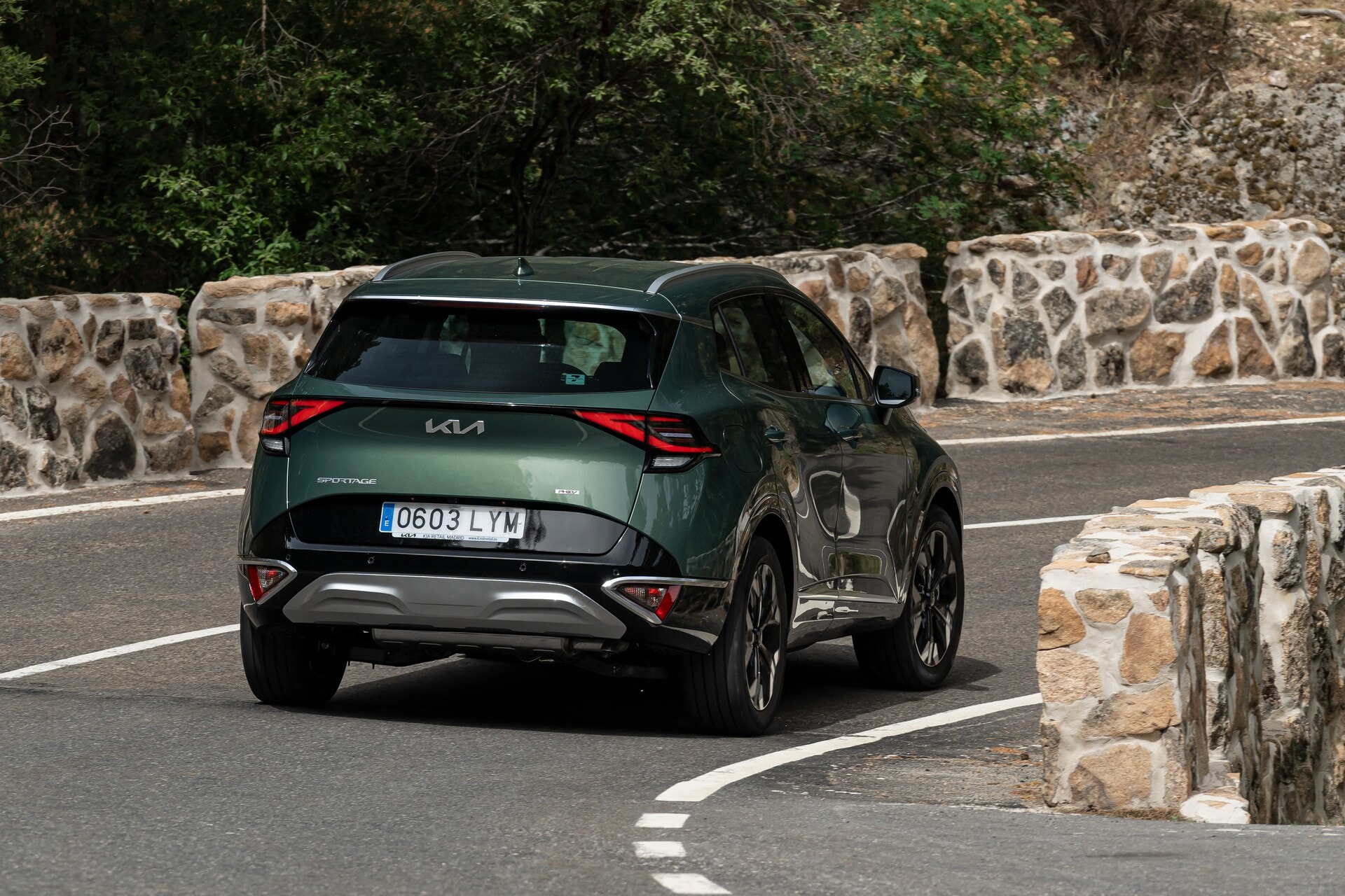 Kia Sportage híbrido capturado en movimiento desde una perspectiva trasera.