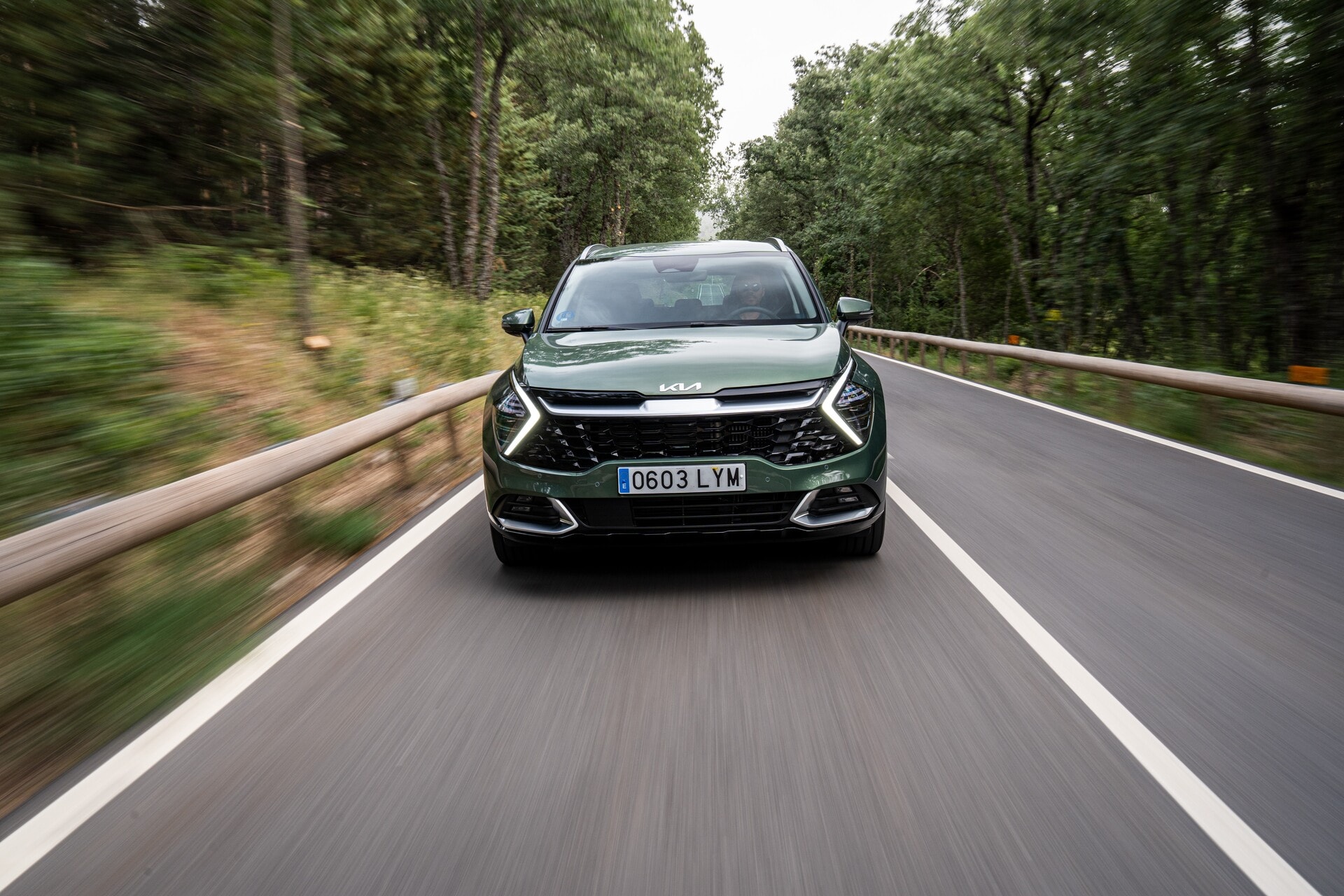 Imagen del Kia Sportage híbrido en carretera con vista delantera y enfoque dinámico.